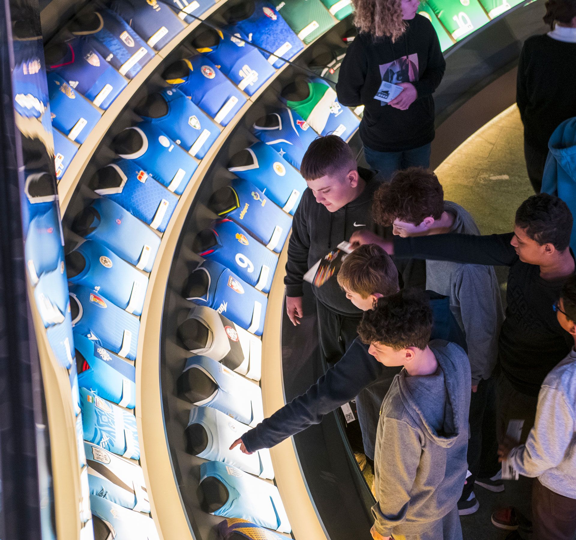 Interior view of the FIFA Museum. The group of young people is looking at the different jerseys.