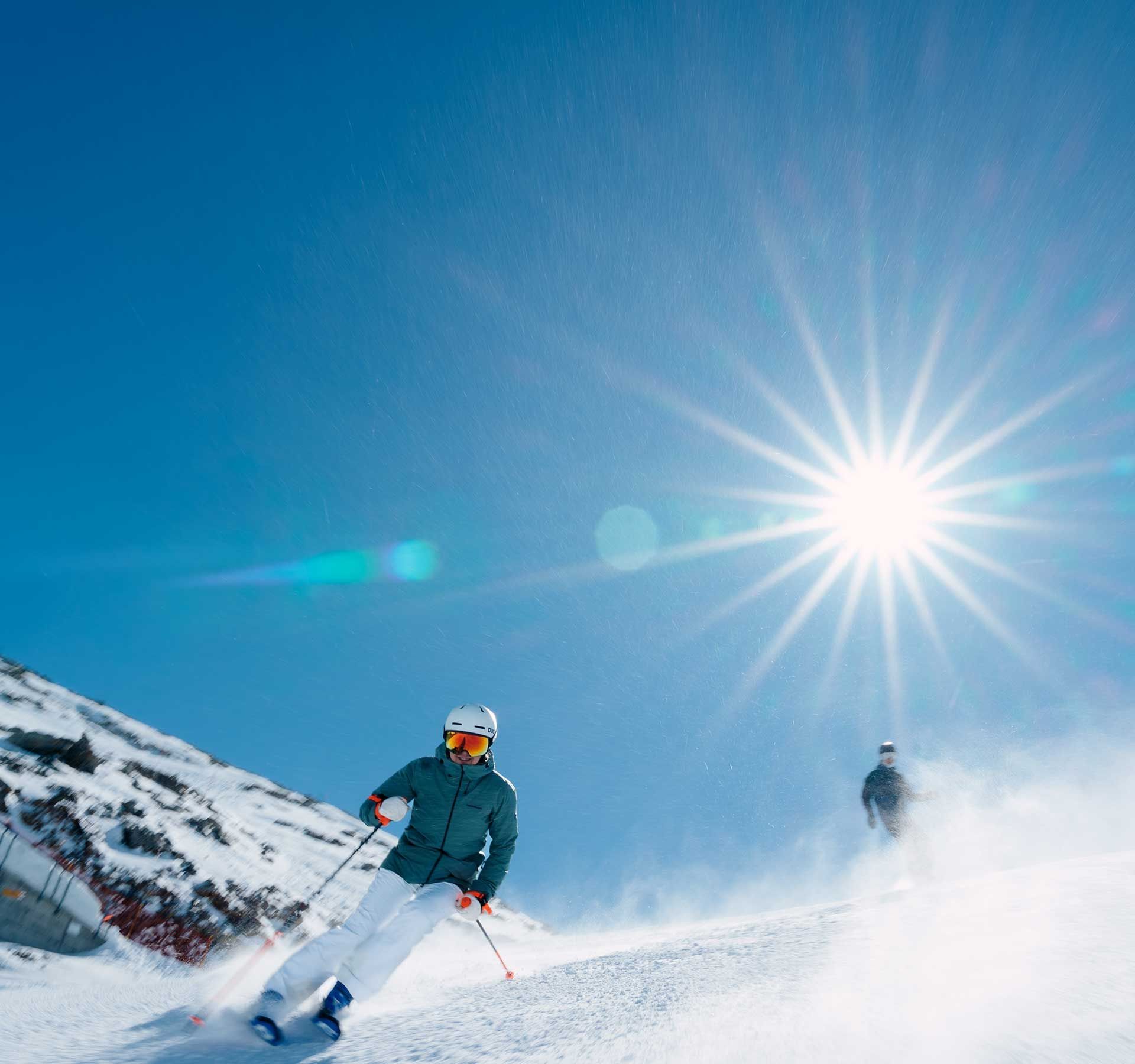 Deux personnes skiant sur une pente enneigée.