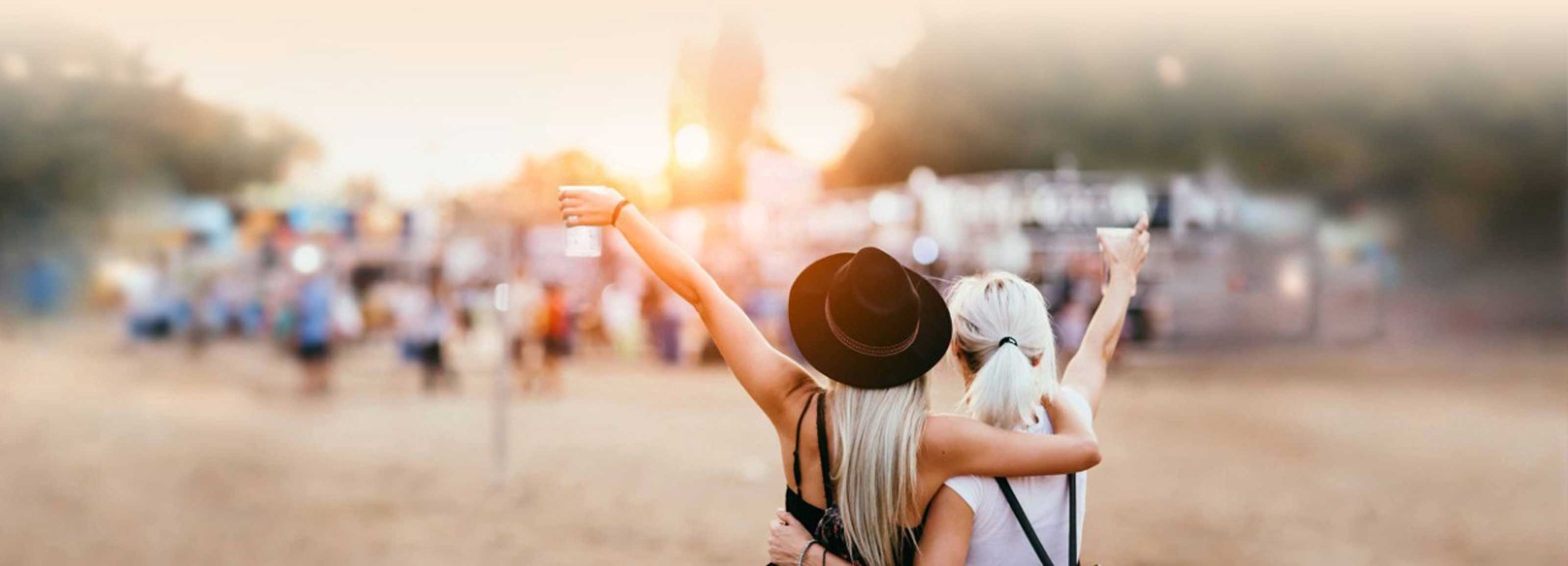 Zwei Festivalbesucherinnen stehen vor dem Festivalgelände und freuen sich auf das Event.