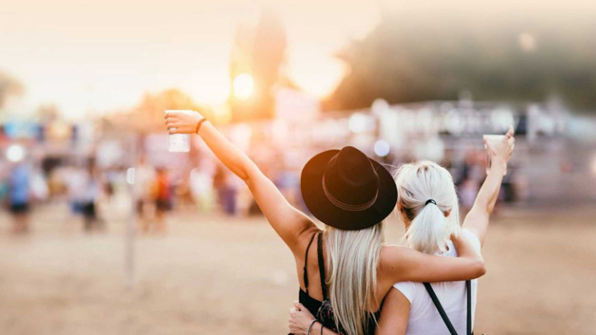 Zwei Festivalbesucherinnen stehen vor dem Festivalgelände und freuen sich auf das Event.