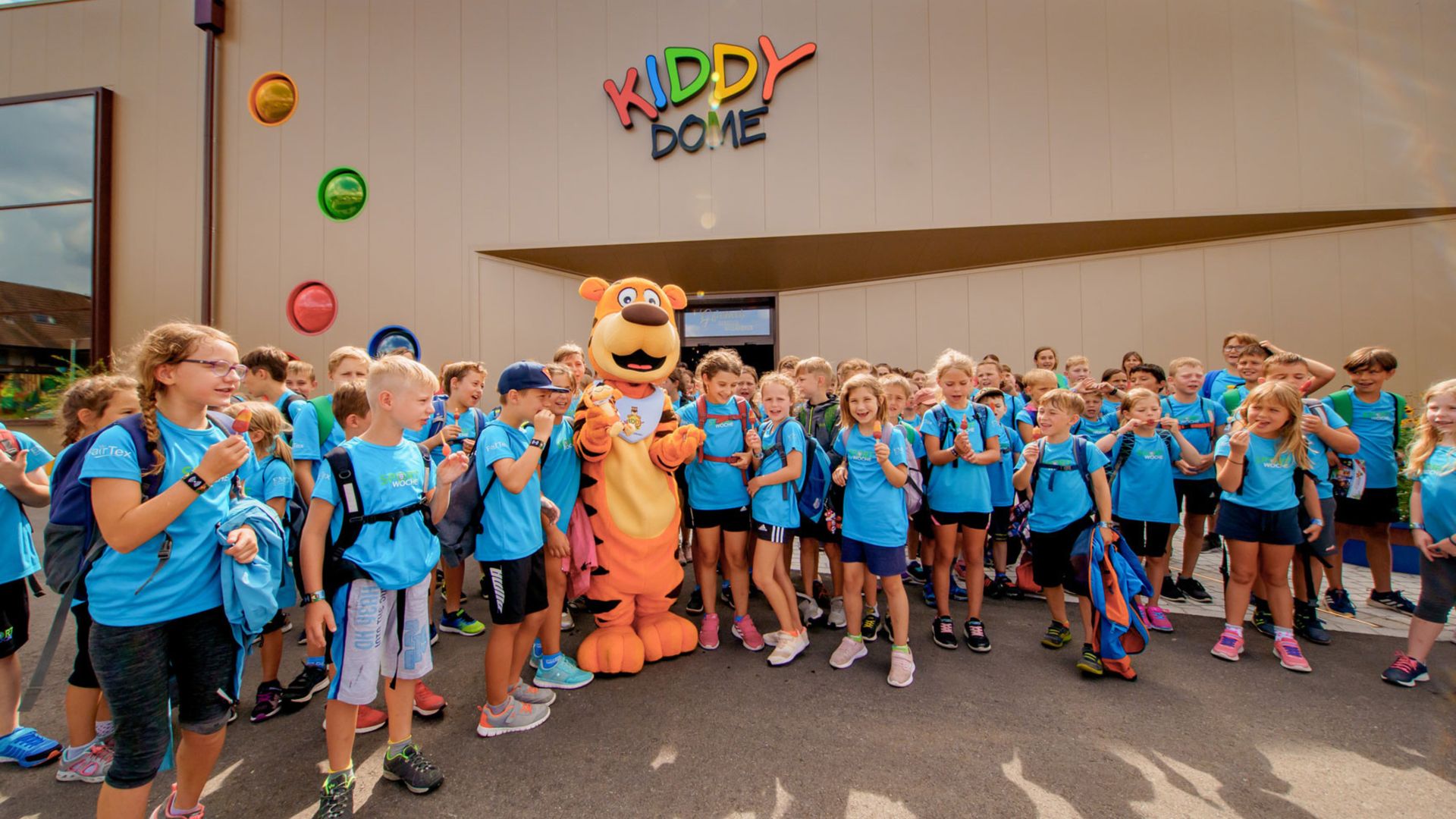 A large class with the Fluffy Tiger in the middle is standing next to the entrance.
