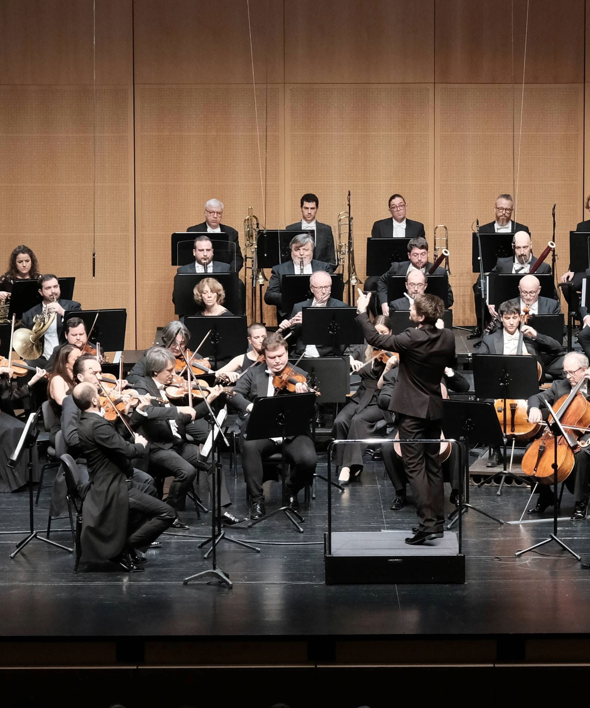 Das Orchestra della Svizzera italiana at a concert, musicians on stage with their instruments, conducted by the conductor.