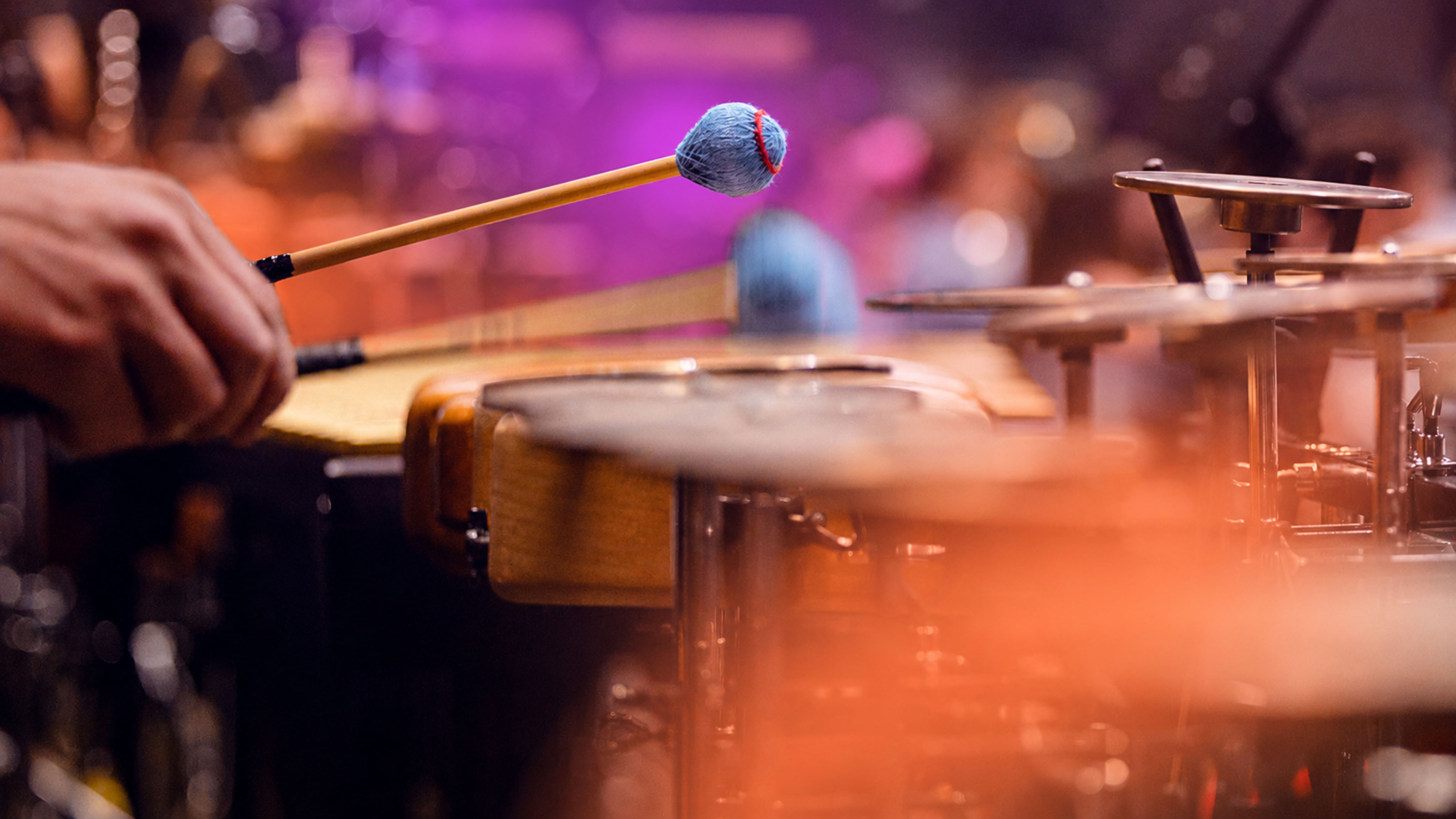 Musicista che suona strumenti a percussione con le bacchette.