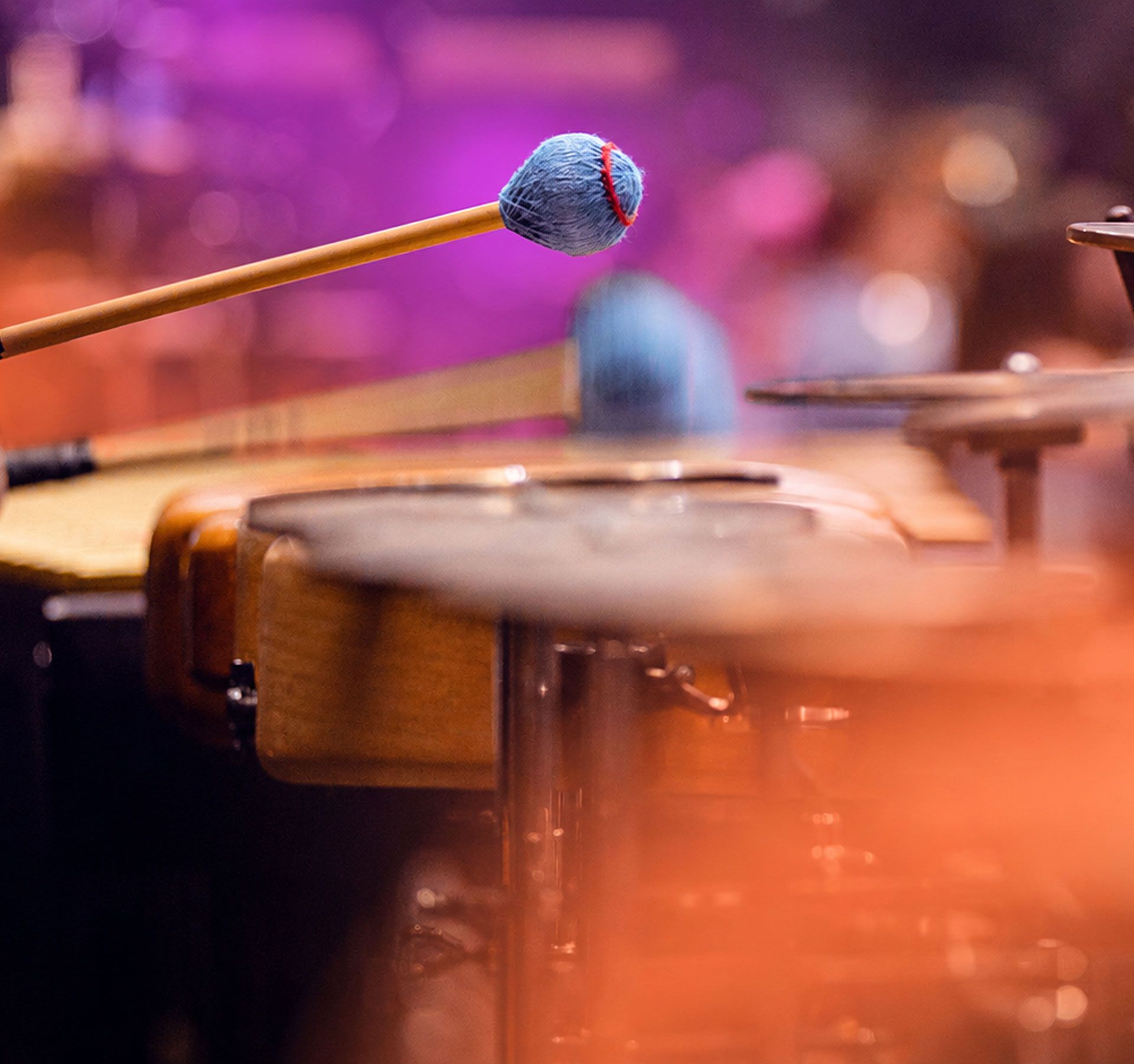 Musician playing percussion instruments with mallets.