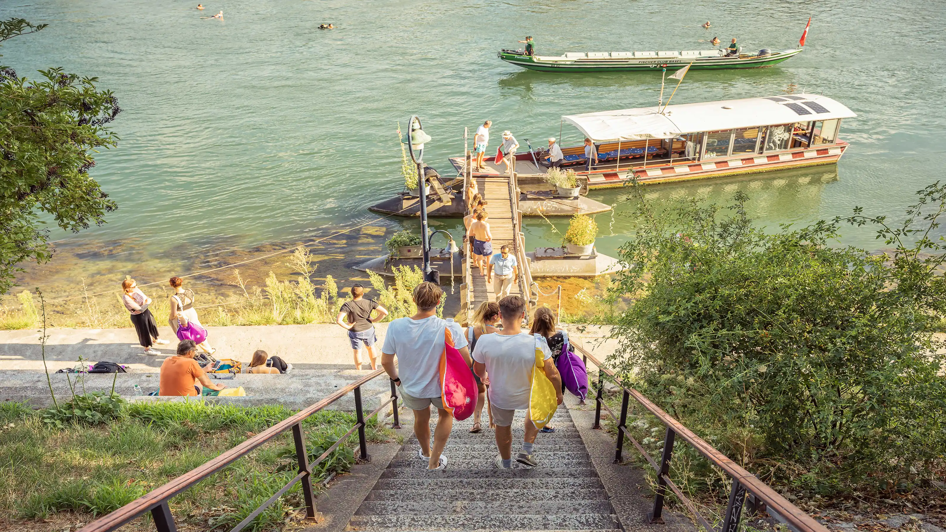 Eine bunt gemischte Gruppe von Personen steigt eine Treppe hinunter, unterhält sich und geniesst ihre Umgebung.