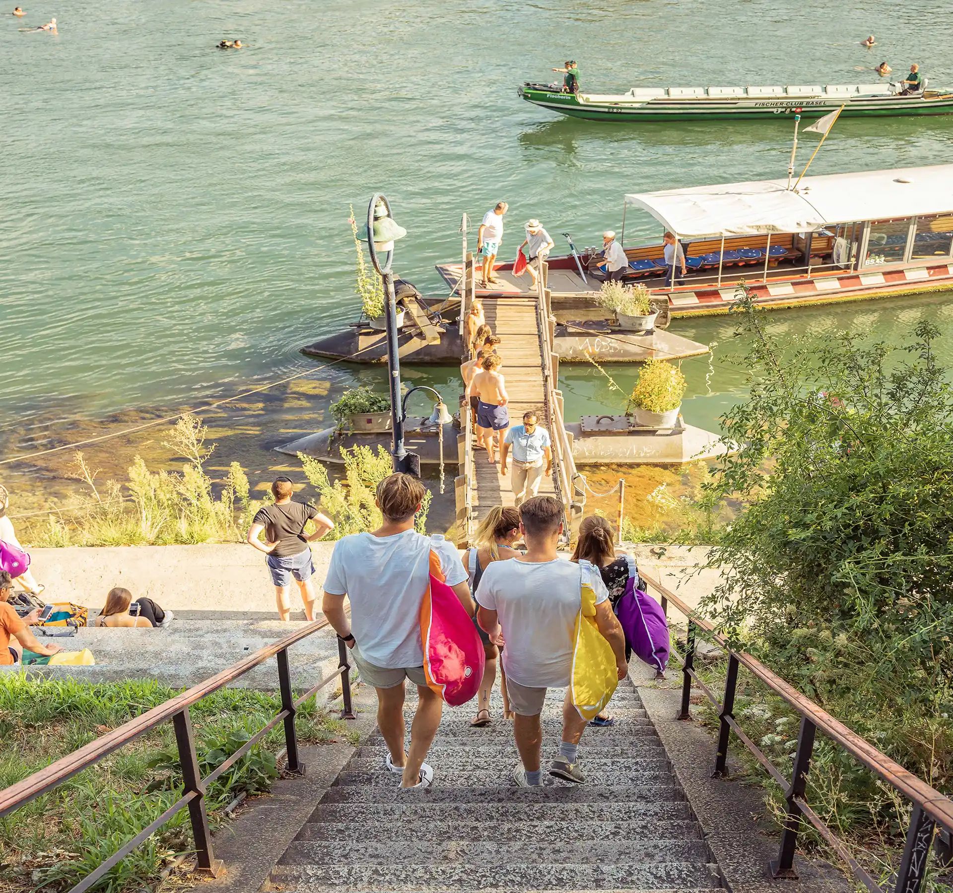 Eine bunt gemischte Gruppe von Personen steigt eine Treppe hinunter, unterhält sich und geniesst ihre Umgebung.