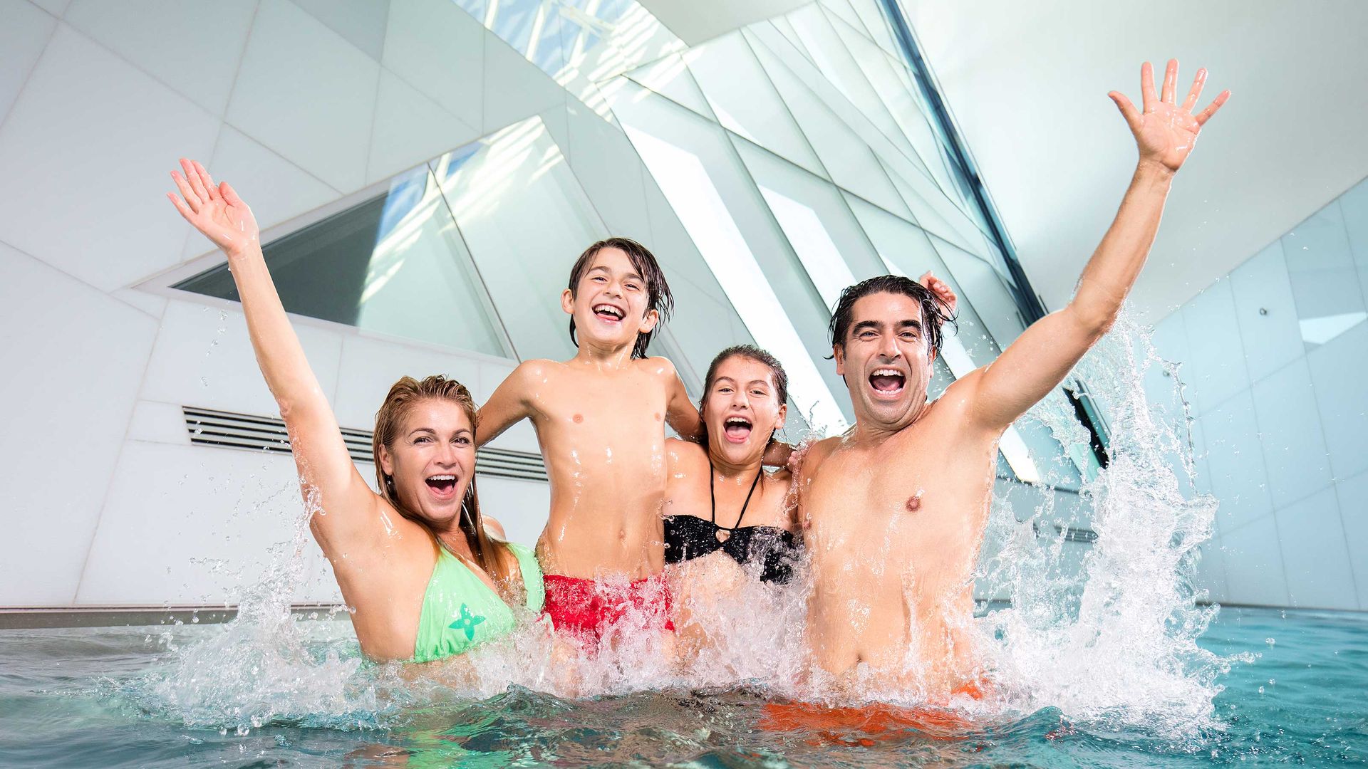 Una famiglia con 2 bambini si diverte nella piscina avventura di Bernaqua.
