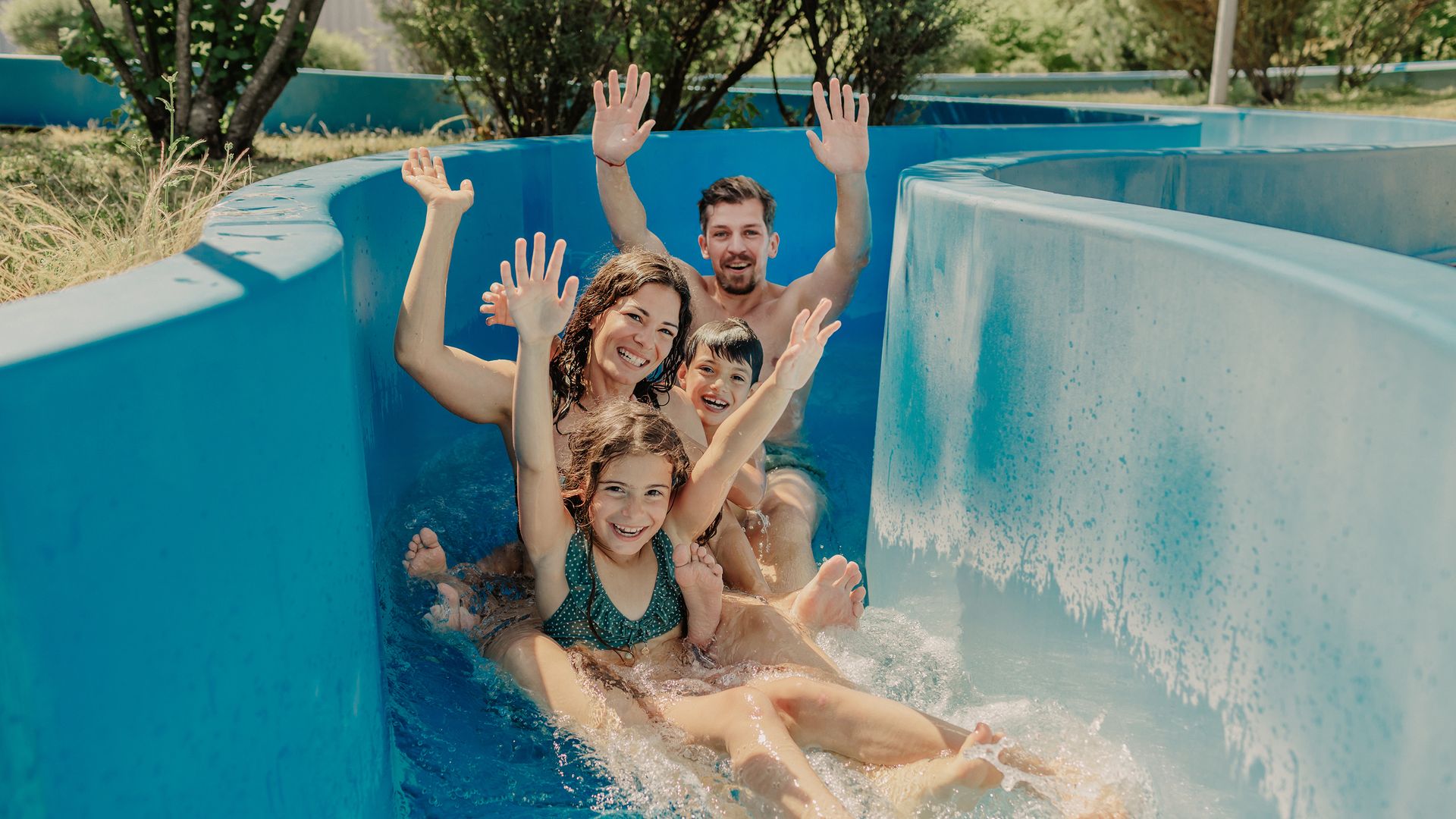 Una coppia in accappatoio passeggia a bordo piscina.