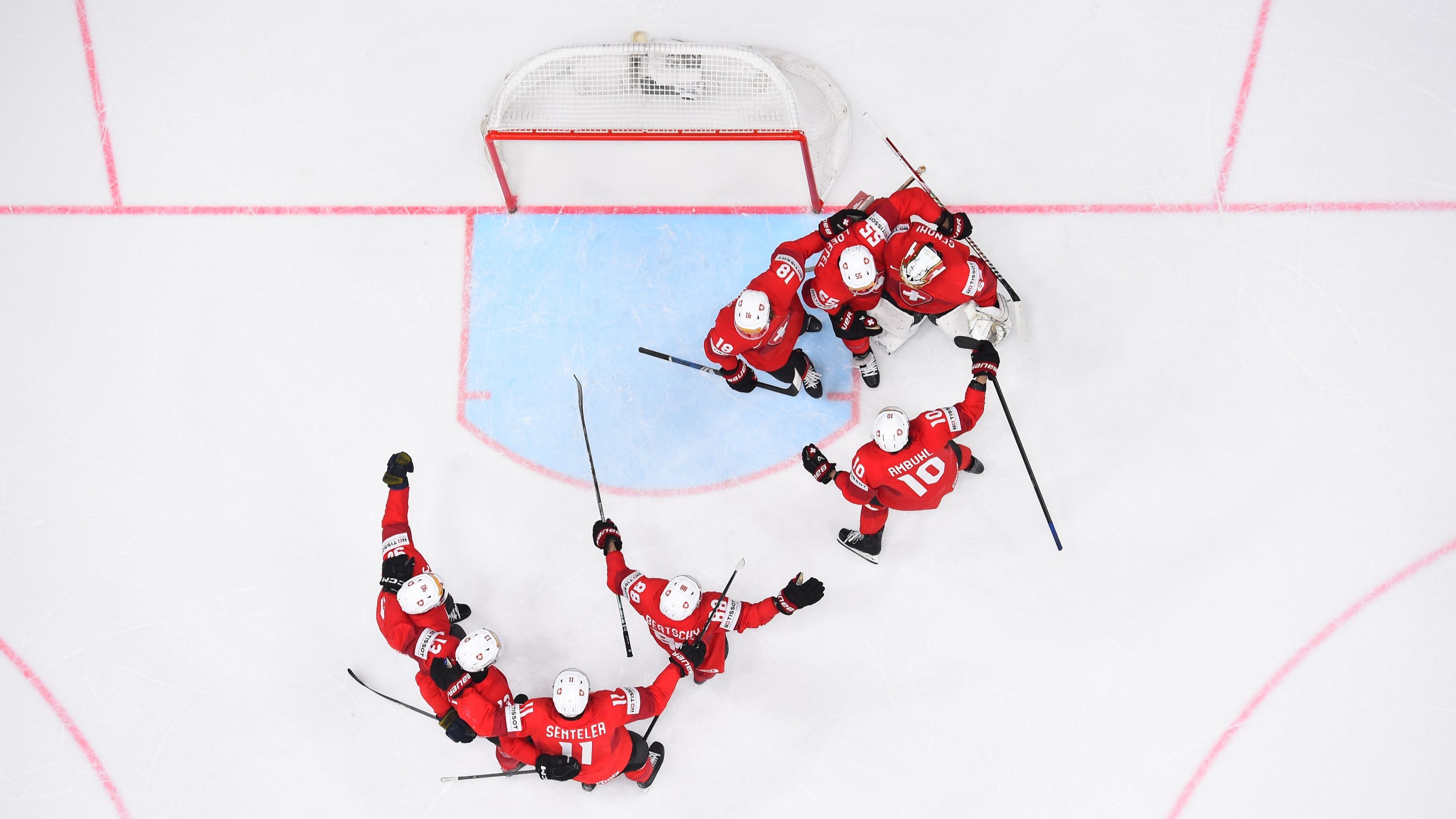 Swiss ice hockey team in action, view from the goal towards the puck