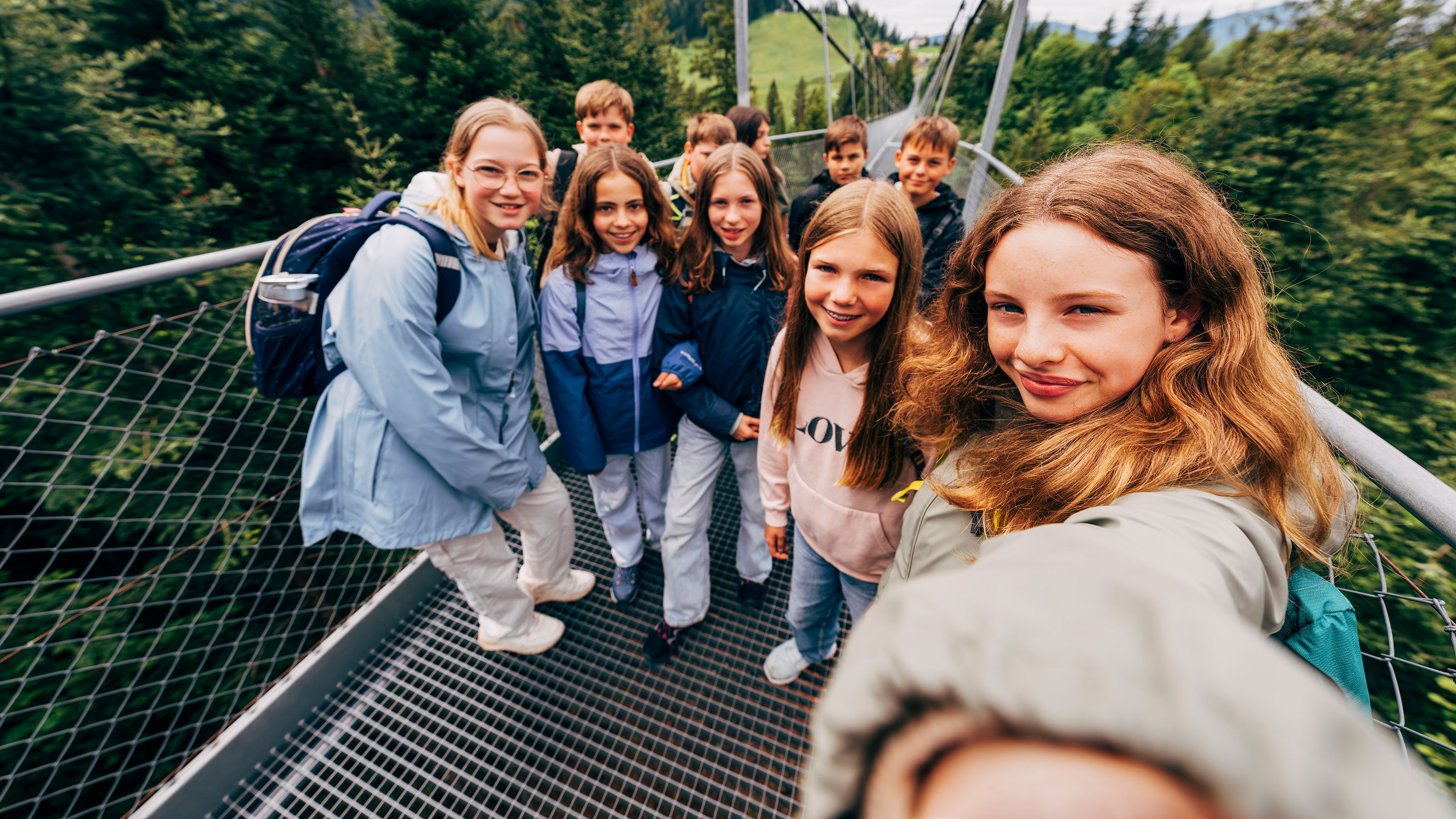 Menschen laufen gemeinsam über eine beeindruckende Hängebrücke.