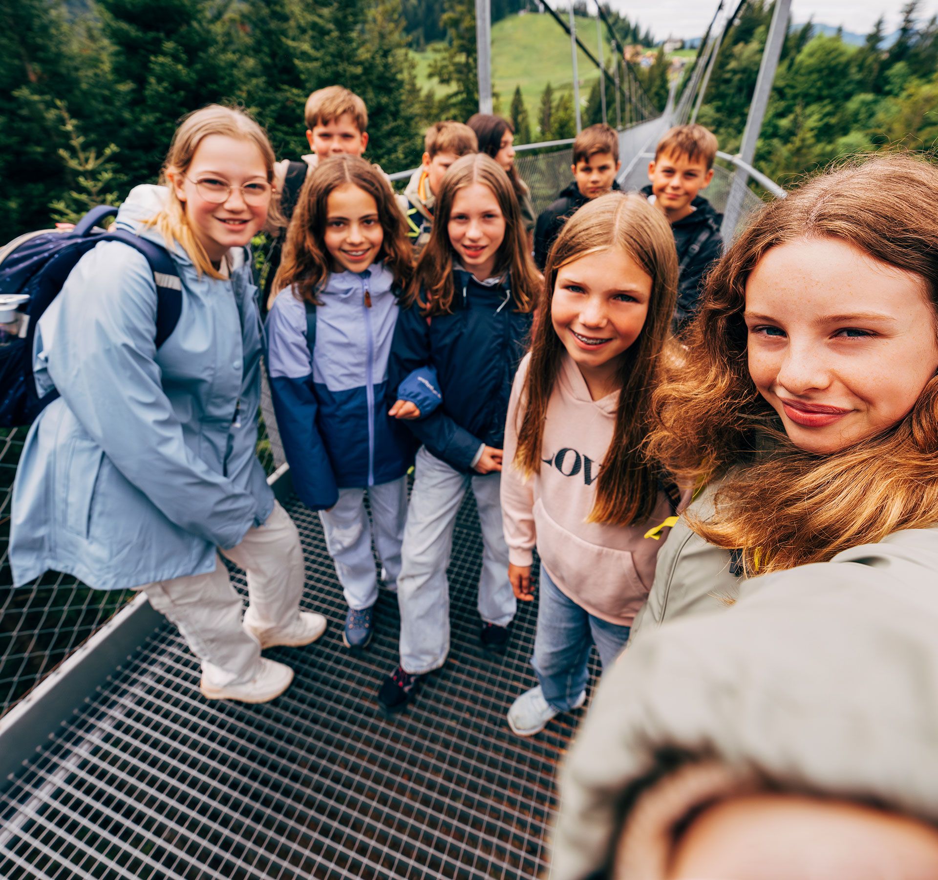 Menschen laufen gemeinsam über eine beeindruckende Hängebrücke.