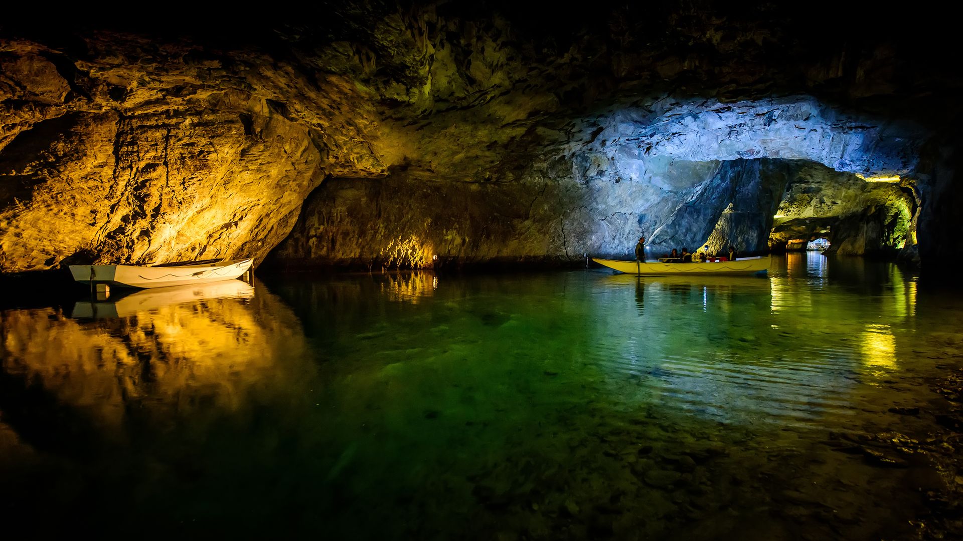 Un lac souterrain éclairé sur lequel les visiteurs glissent dans un bateau.