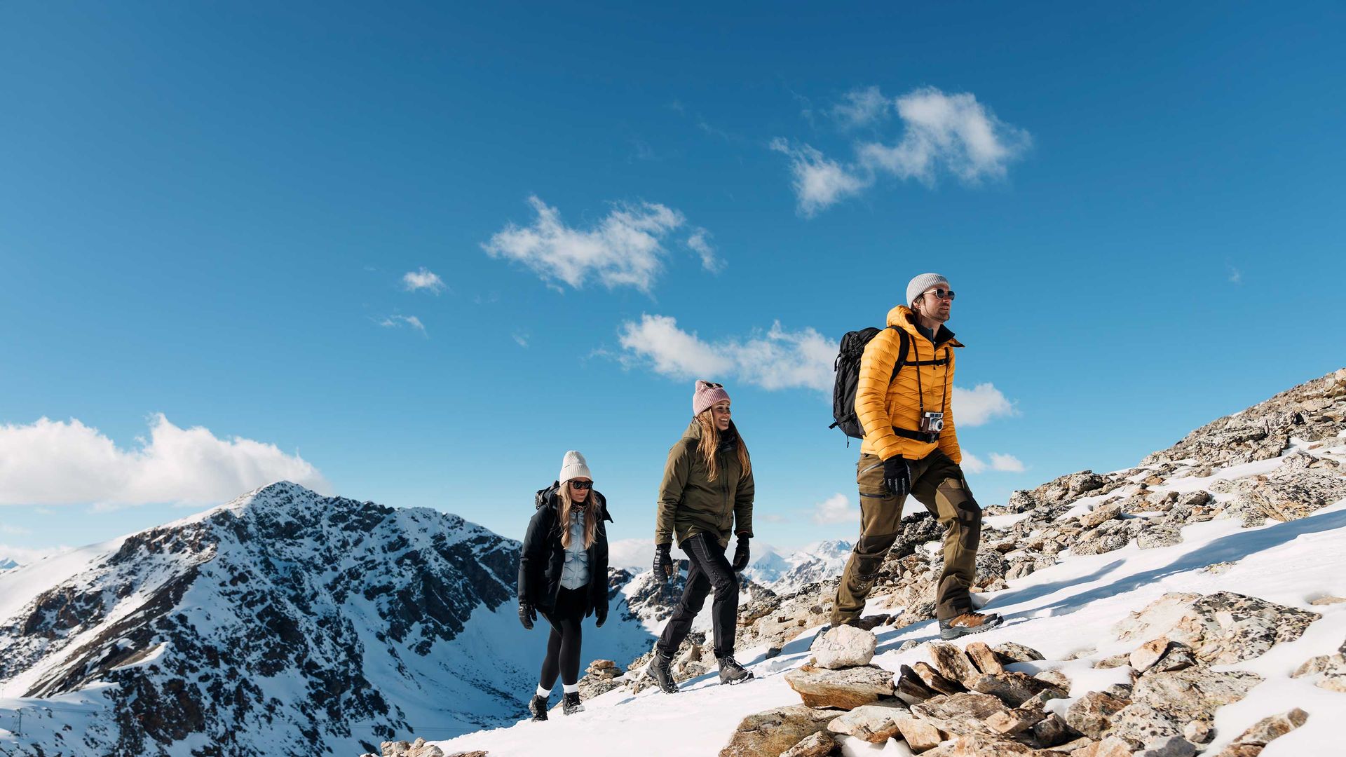 Un gruppo di persone in escursione su una montagna innevata.
