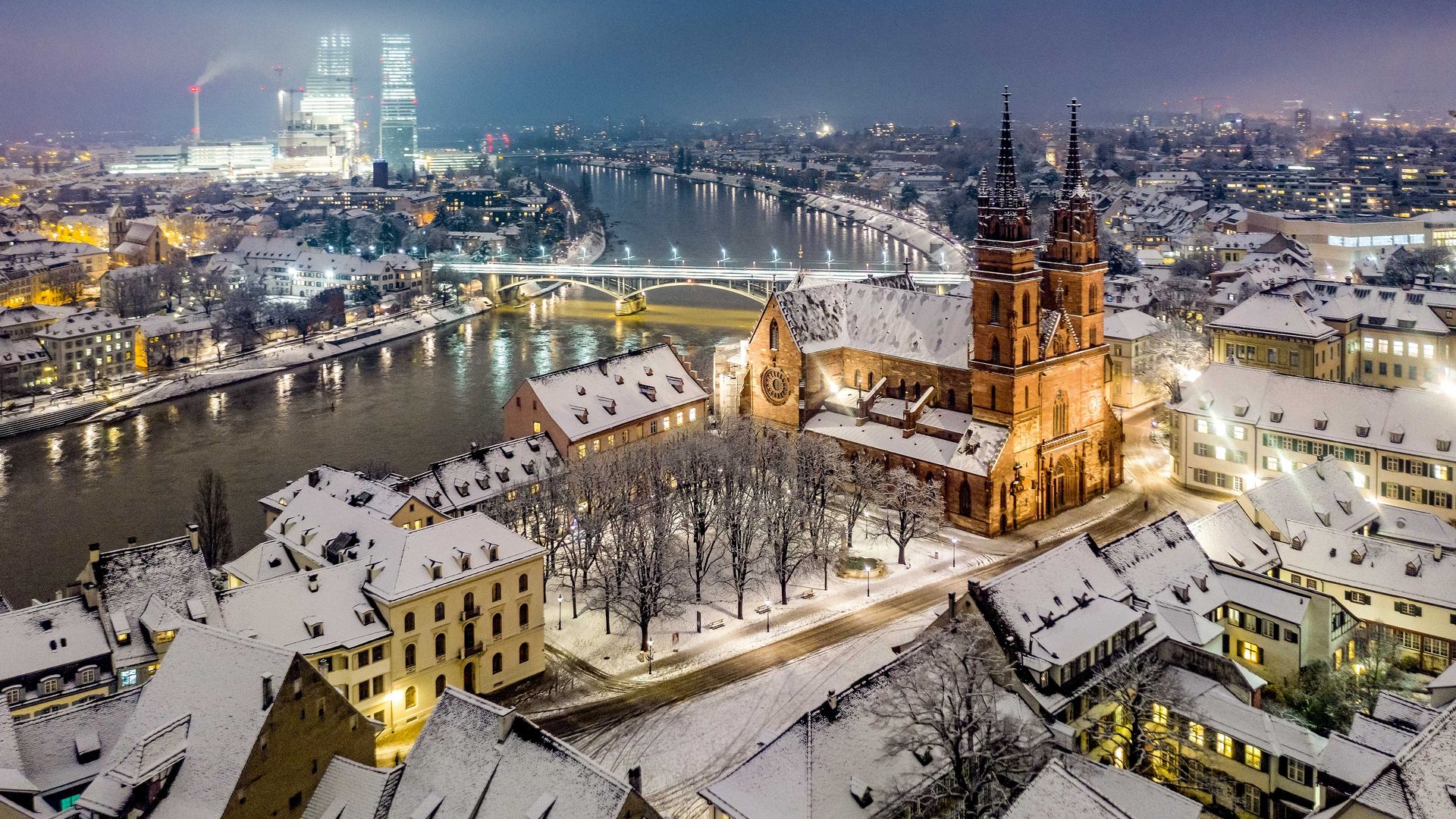 Eine malerische Stadtlandschaft mit schneebedeckten Gebäuden und einem ruhigen, fliessenden Fluss.