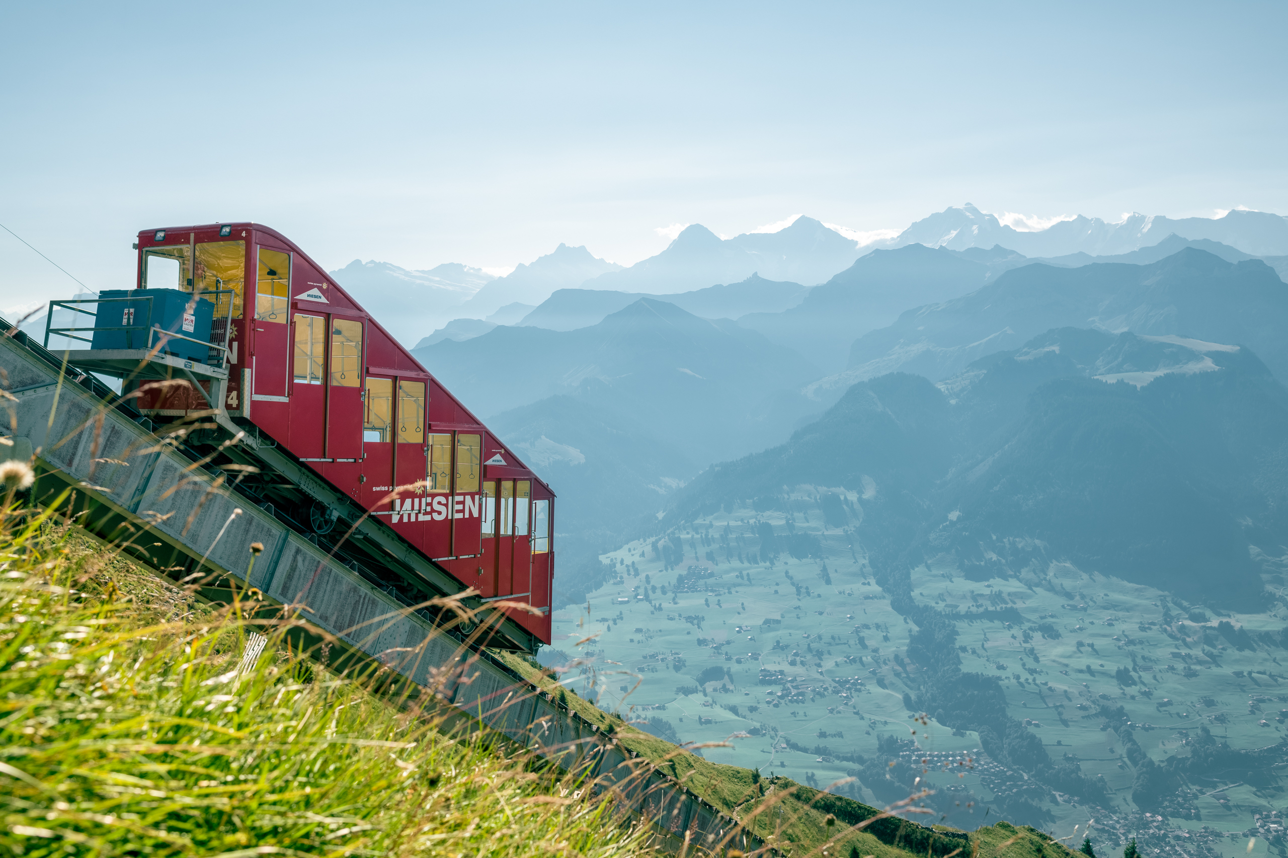 Die Standseilbahn fährt den steilen Niesen hinauf. Die Aussicht ist phänomenal und reicht bis weit an den Horizont. Zu sehen sind diverse Berggifpel.
