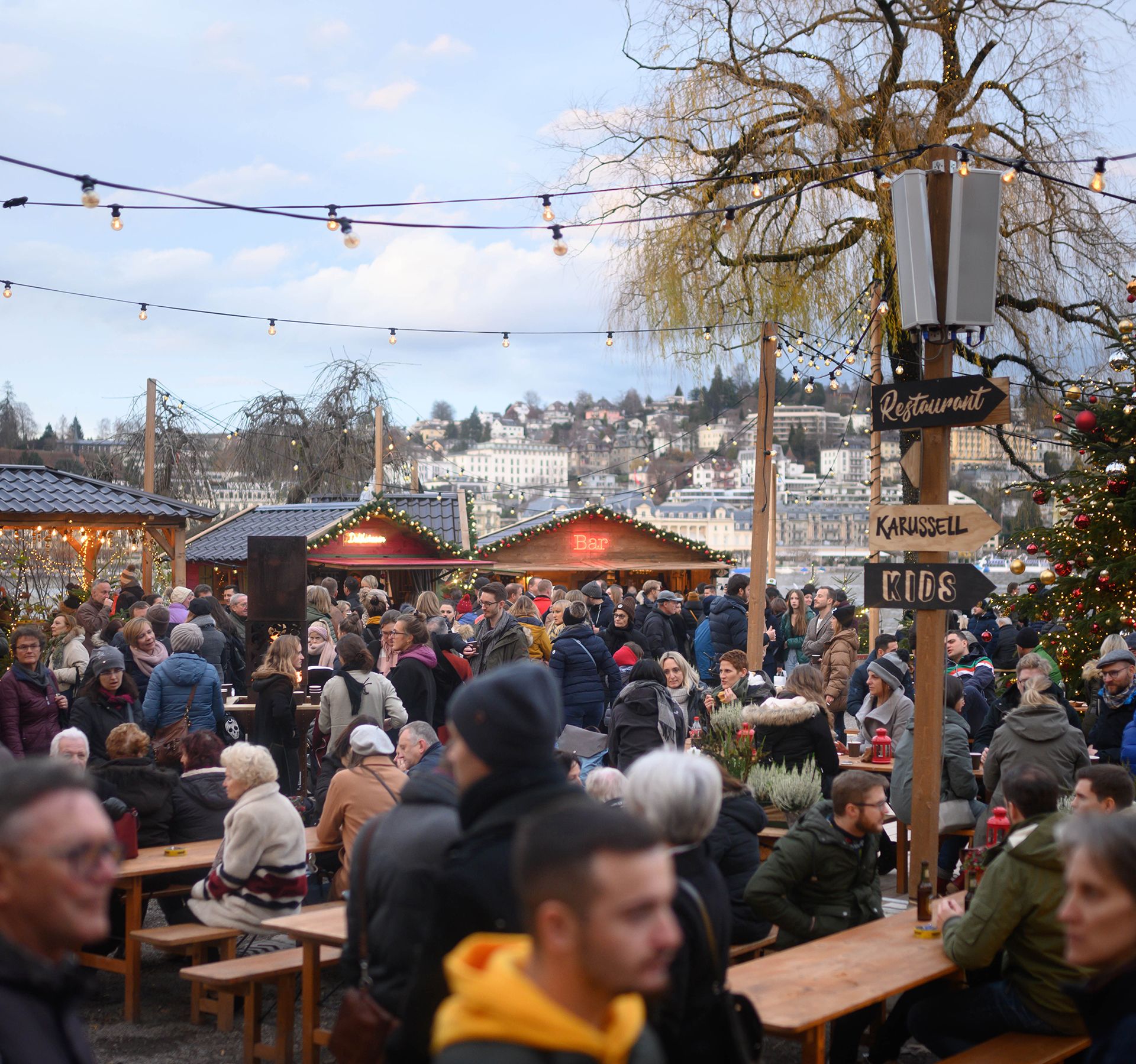 Des personnes flânant tranquillement dans les chalets du marché de Noël de Lucerne.