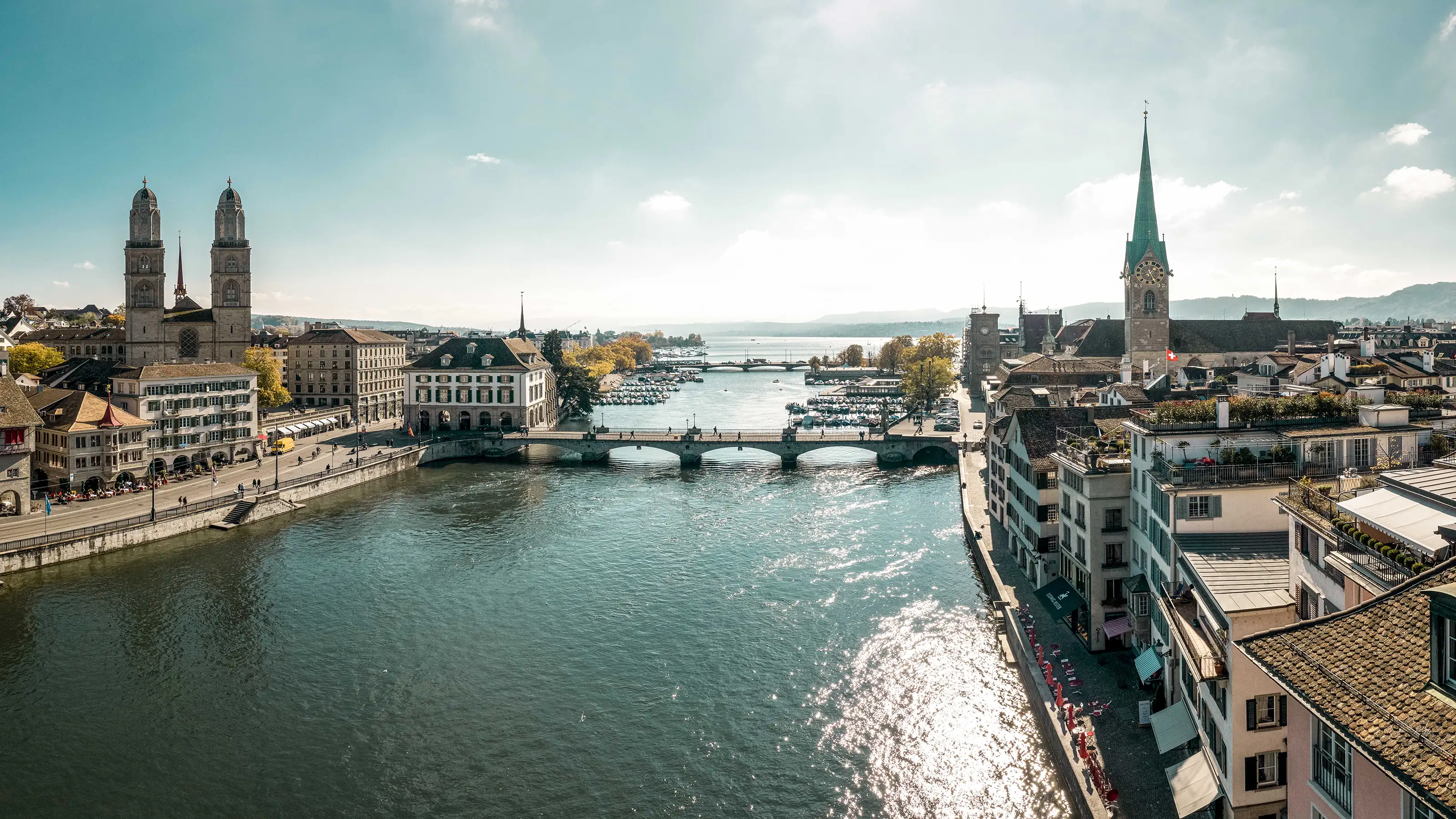 Ein Bild von Zürich, Schweiz, das die Kathedrale der Stadt und den Fluss zeigt, der die städtische Landschaft bereichert.