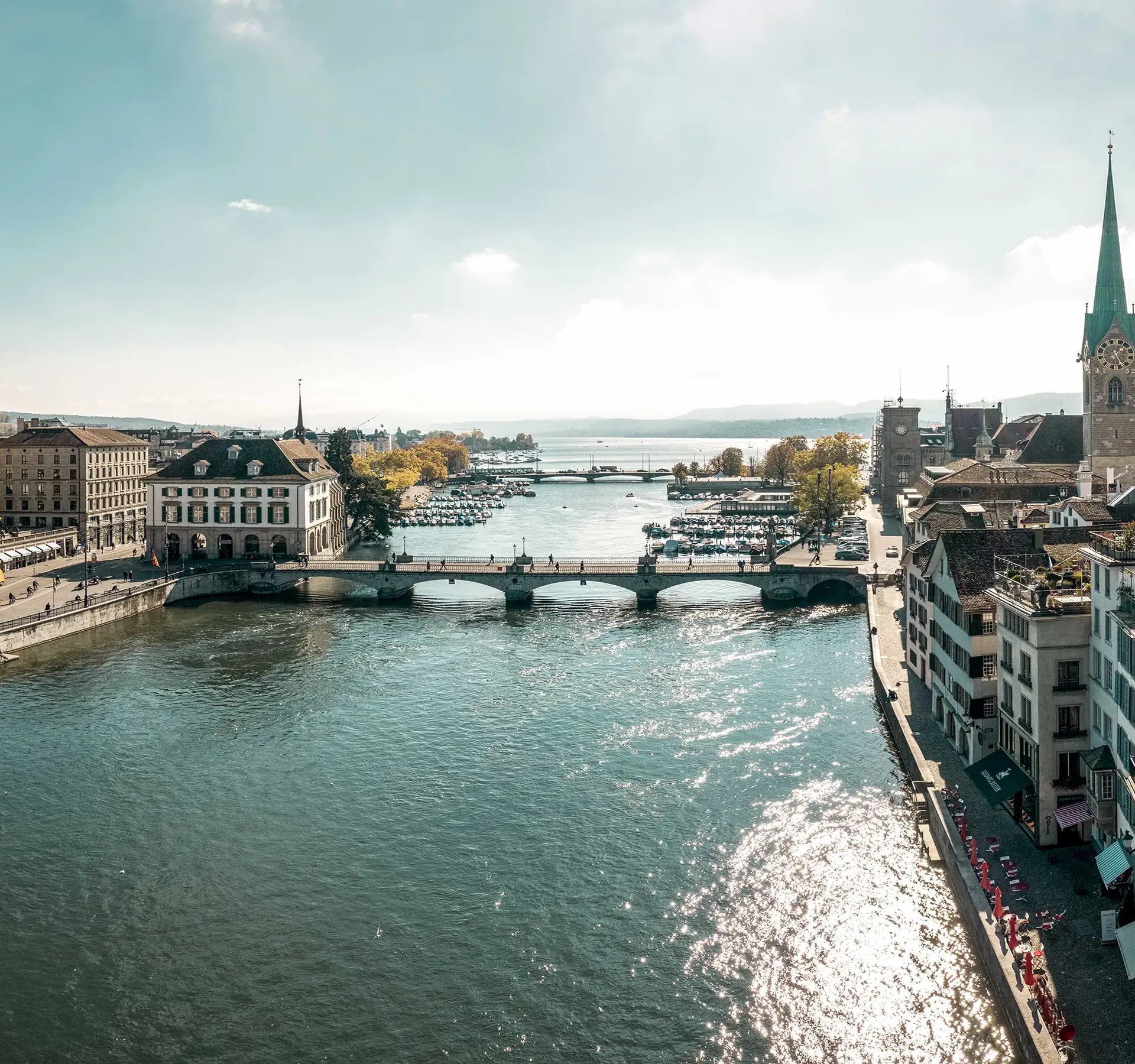 Ein Bild von Zürich, Schweiz, das die Kathedrale der Stadt und den Fluss zeigt, der die städtische Landschaft bereichert.