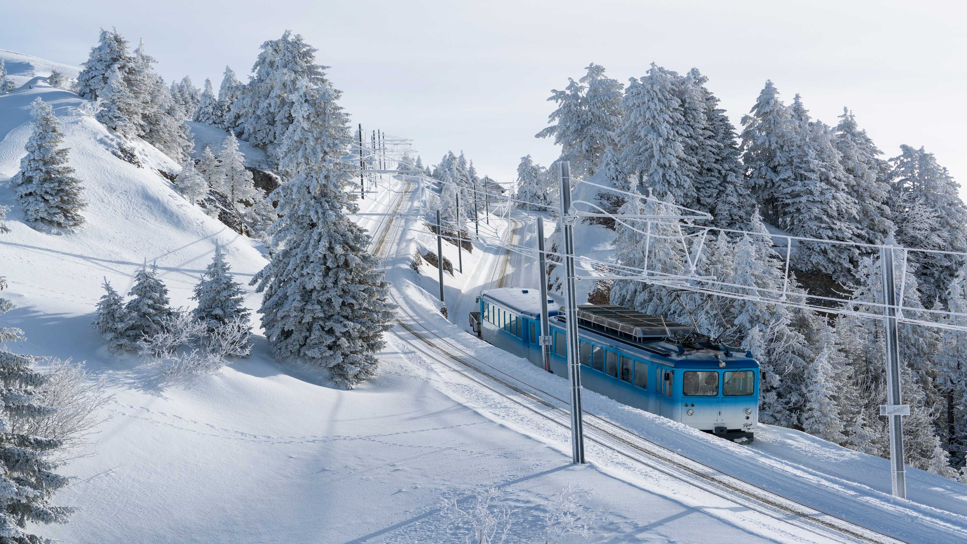 The Rigi train travels through a picturesque mountain landscape on a winter’s day.