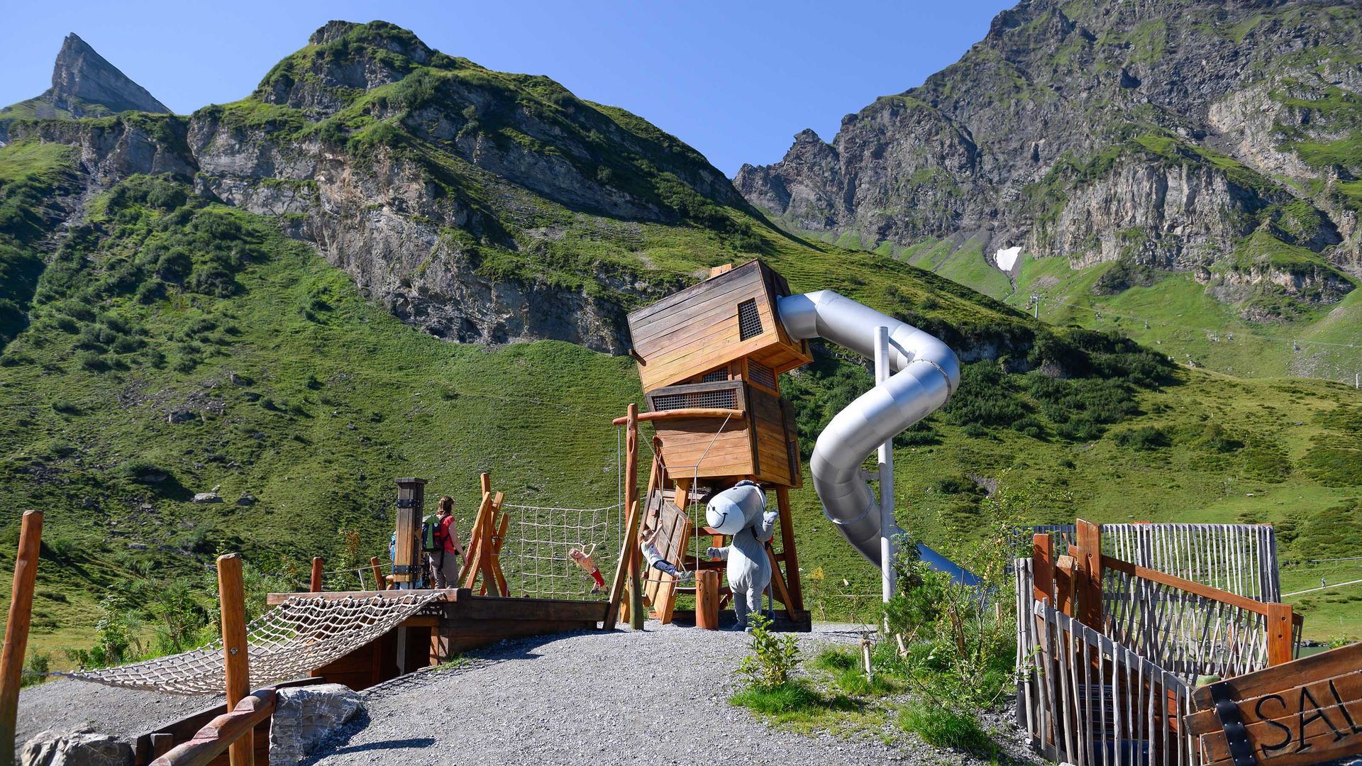 Blick auf den Schmuggler Spielplatz auf Engelberg-Trübsee mit Rutschbahn, Kletterhindernissen und vielem mehr. Dazu ein tolles Bergpanorama.