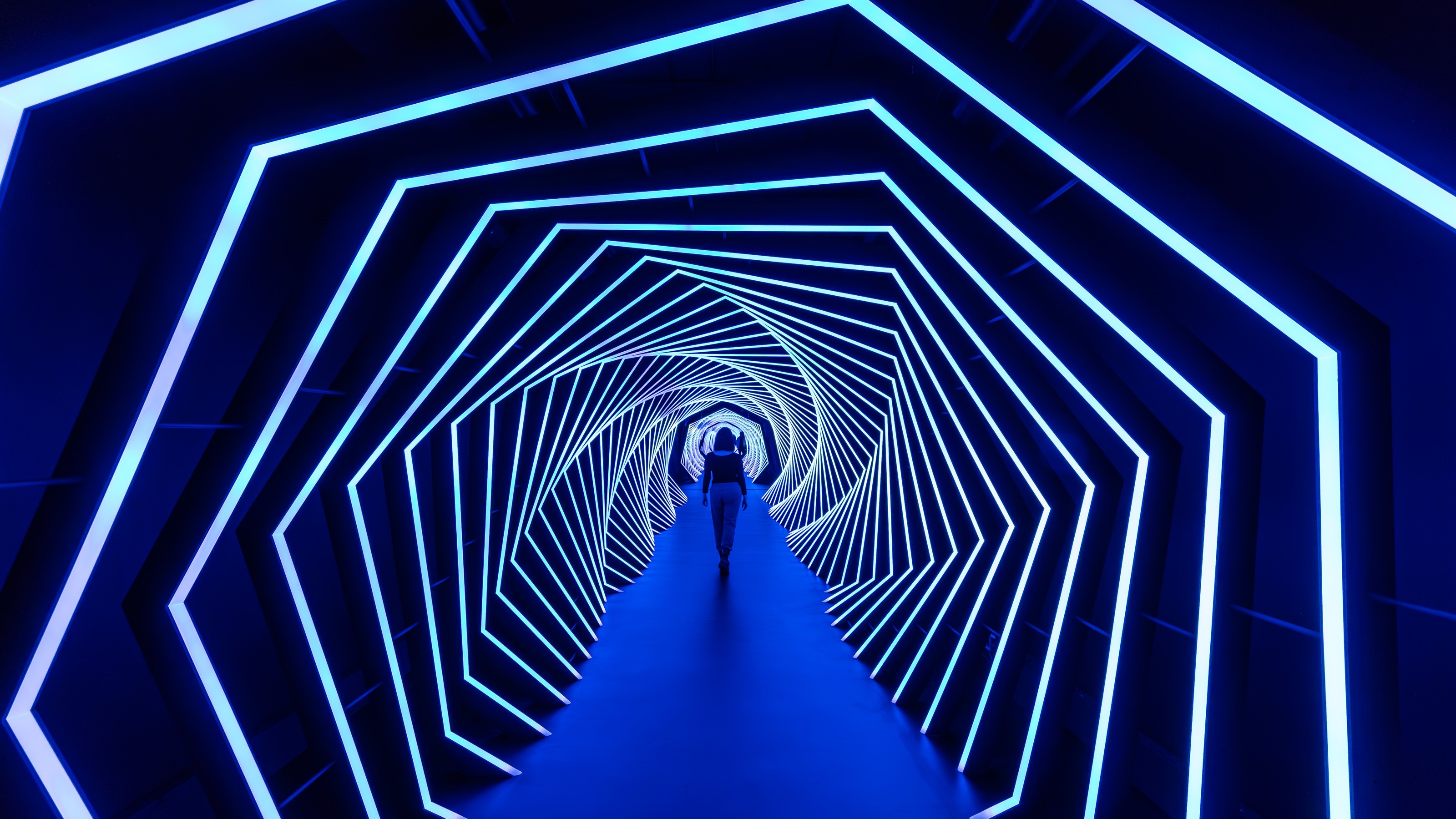 A woman walks through a light tunnel.