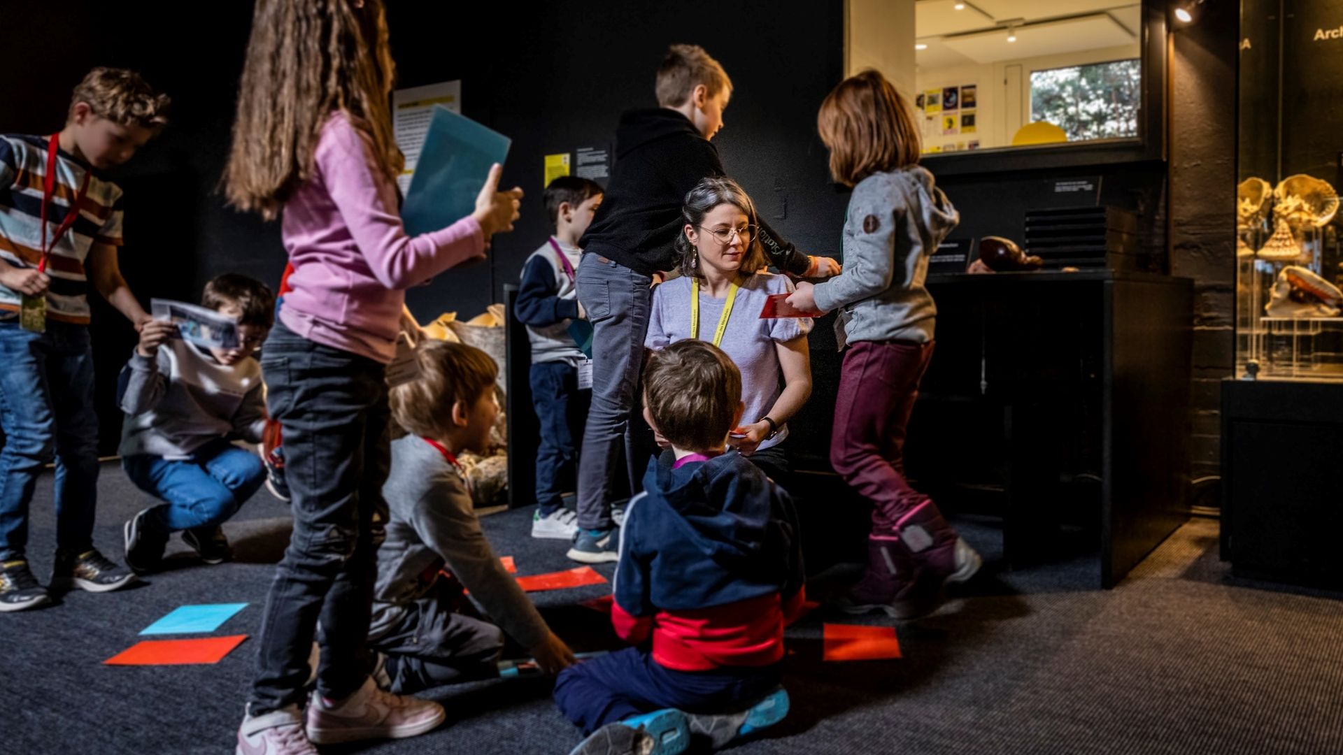 Un gruppo di bambini mostra il proprio lavoro a un supervisore. Un altro gruppo di bambini lavora insieme.