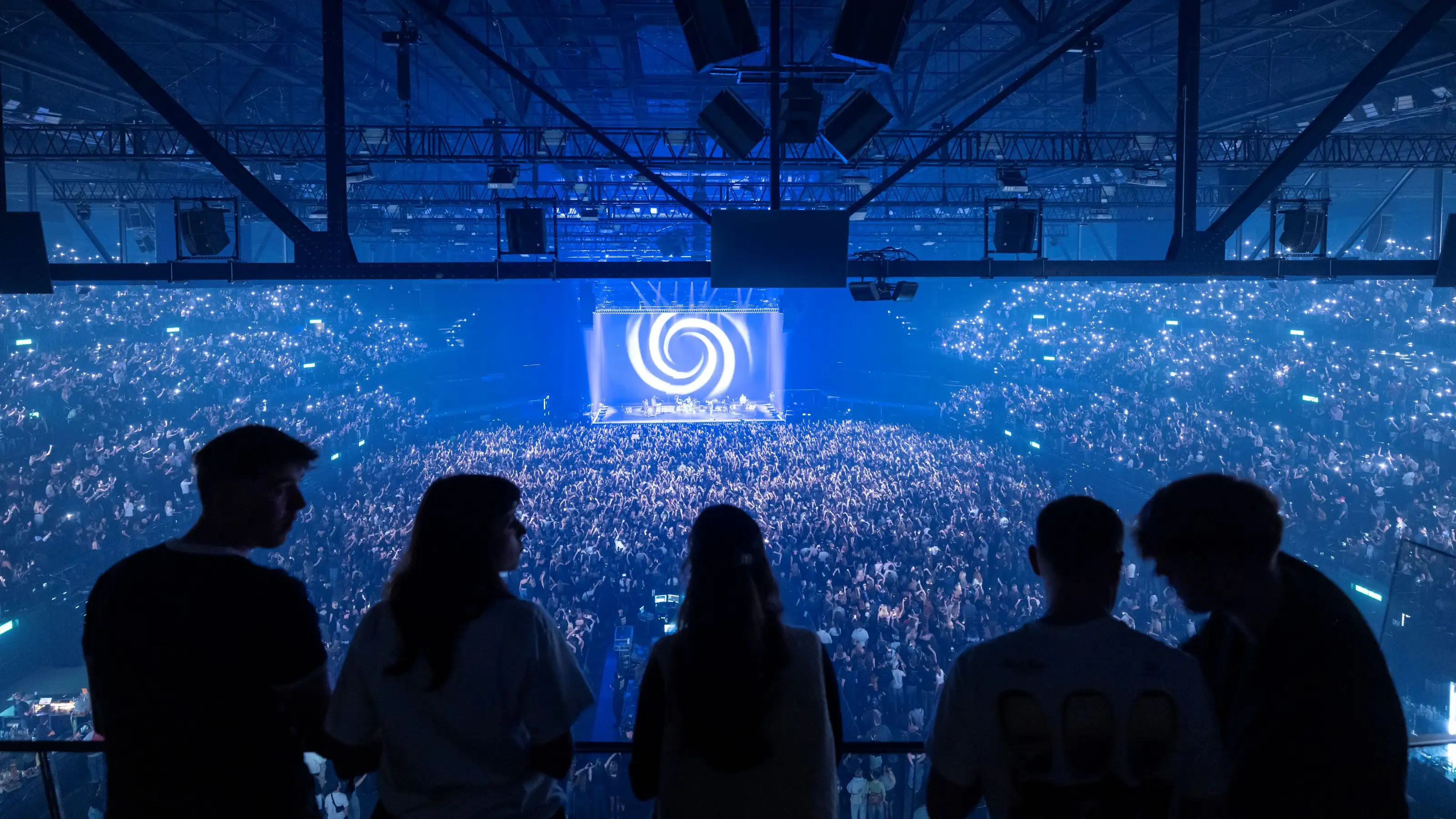 hallenstadion-wettbewerb-silhouetten-vier-personen-grossen-beleuchteten-buehne-halle-publikum