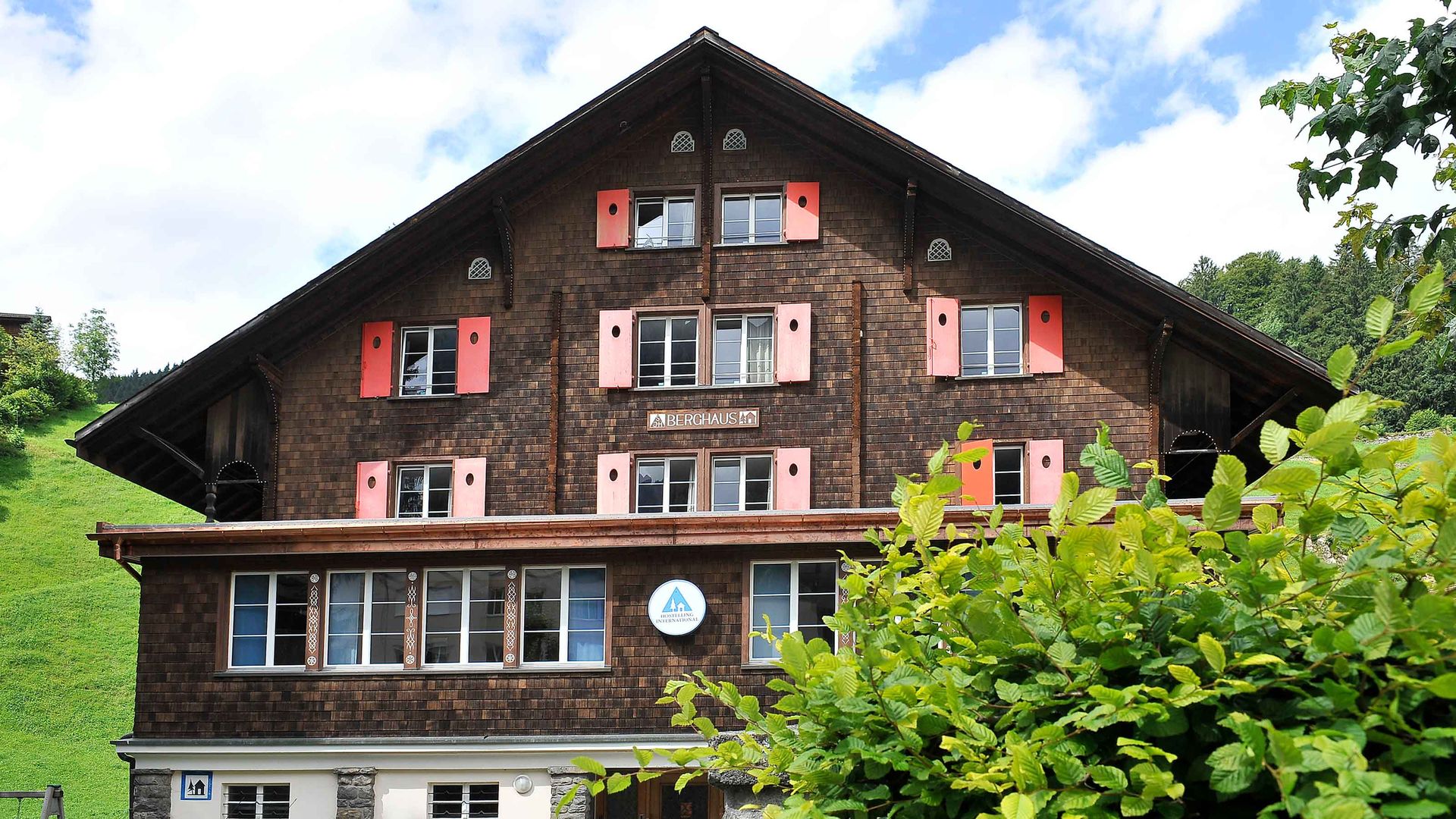 La face avant d'un logement de vacances sur laquelle on peut voir le panneau "Berghaus" et le logo des Auberges de Jeunesse Suisses.