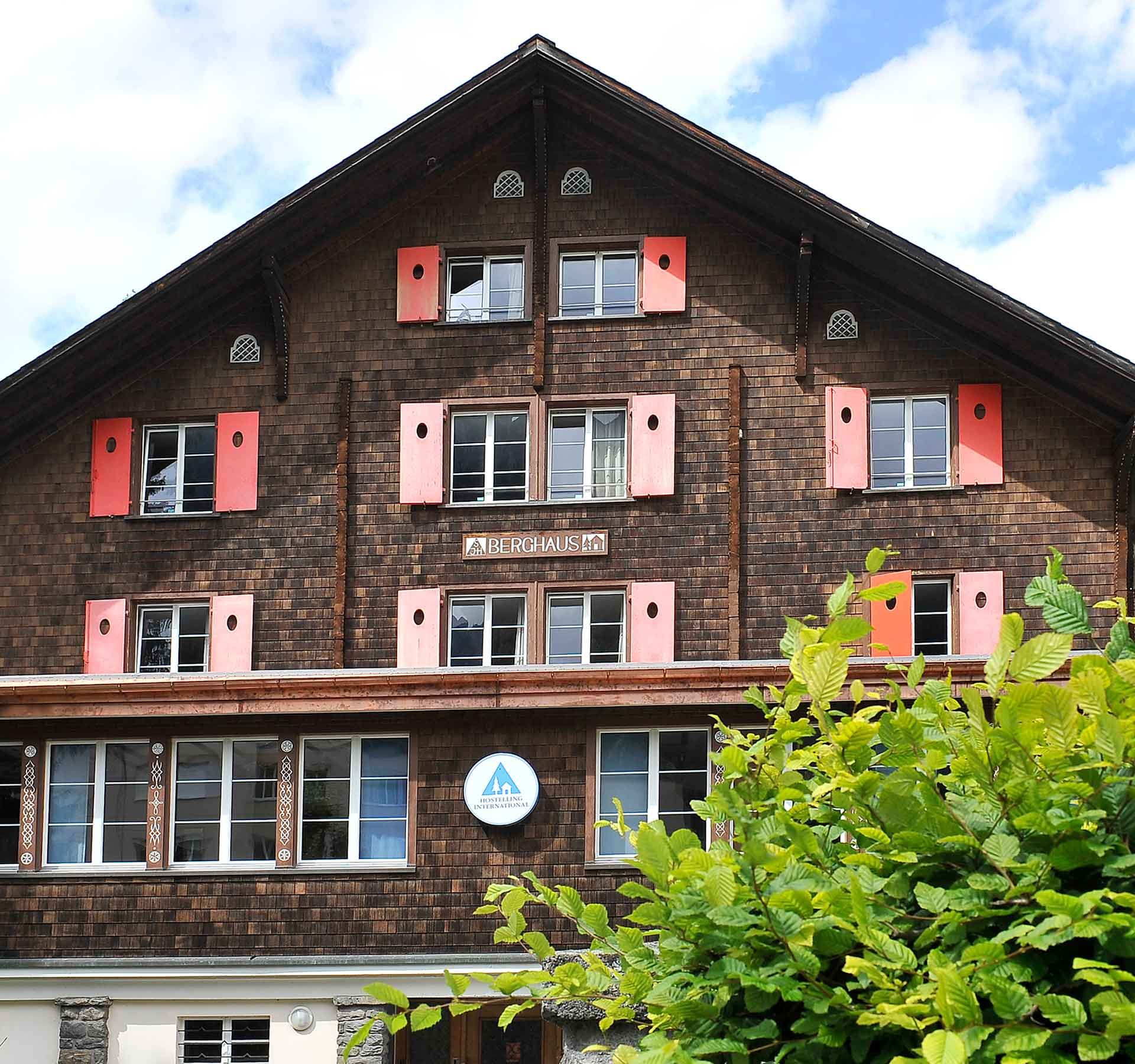 La face avant d'un logement de vacances sur laquelle on peut voir le panneau "Berghaus" et le logo des Auberges de Jeunesse Suisses.