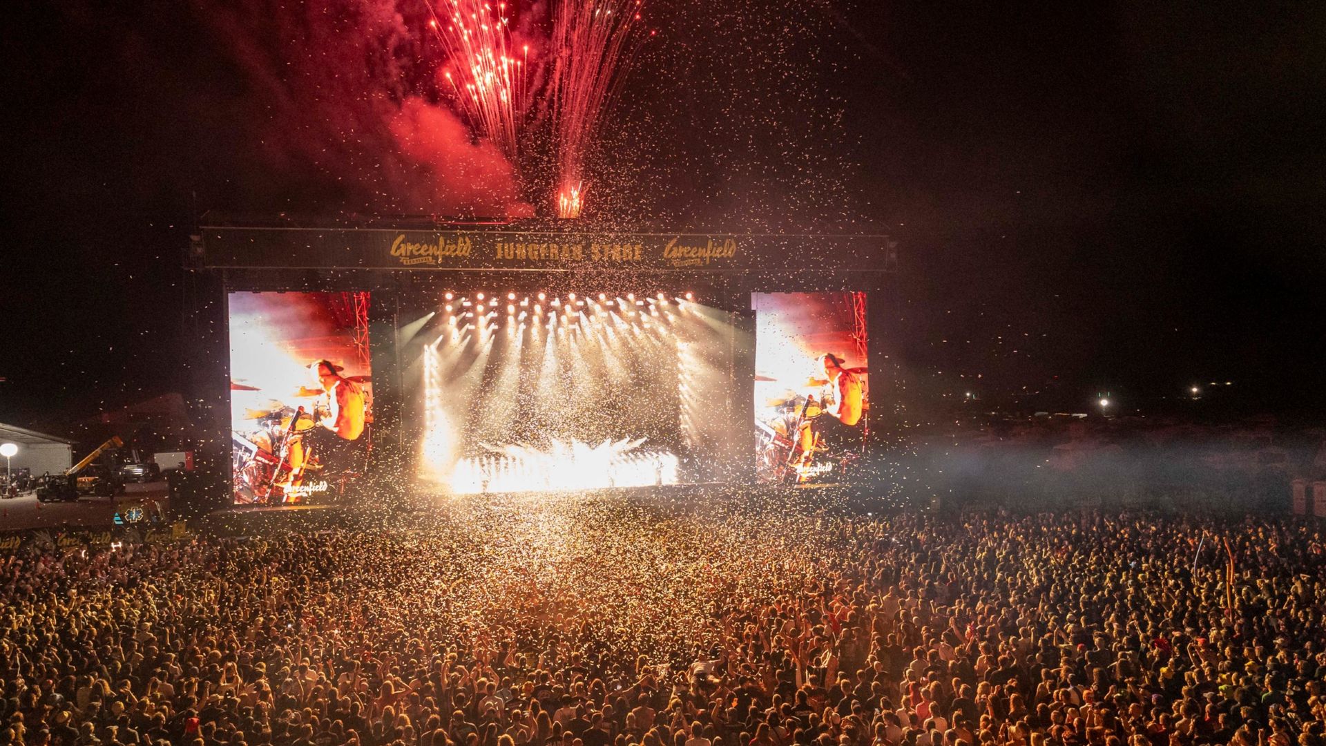 Audience in front of the main stage at the Greenfield Festival in Interlaken with concert atmosphere and lights.