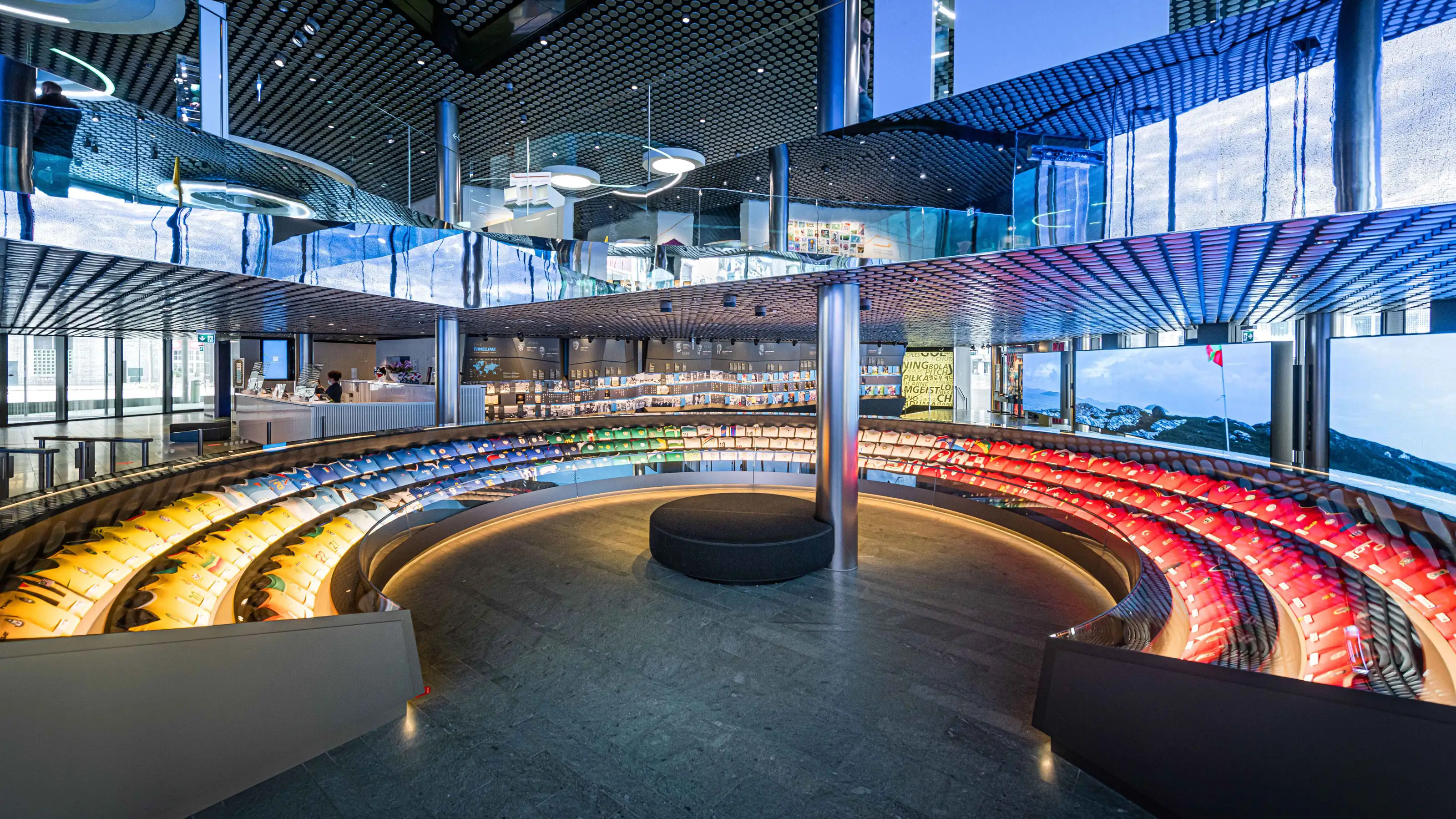 Inside a modern building stands a large glass statue reminiscent of a stadium.
