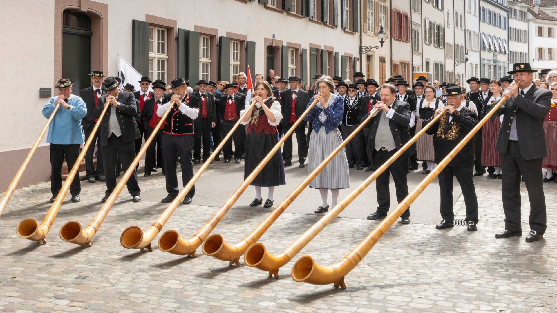 Historisches Schwarzweissfoto einer Jodlergruppe in Tracht beim Auftritt auf einem Festplatz.