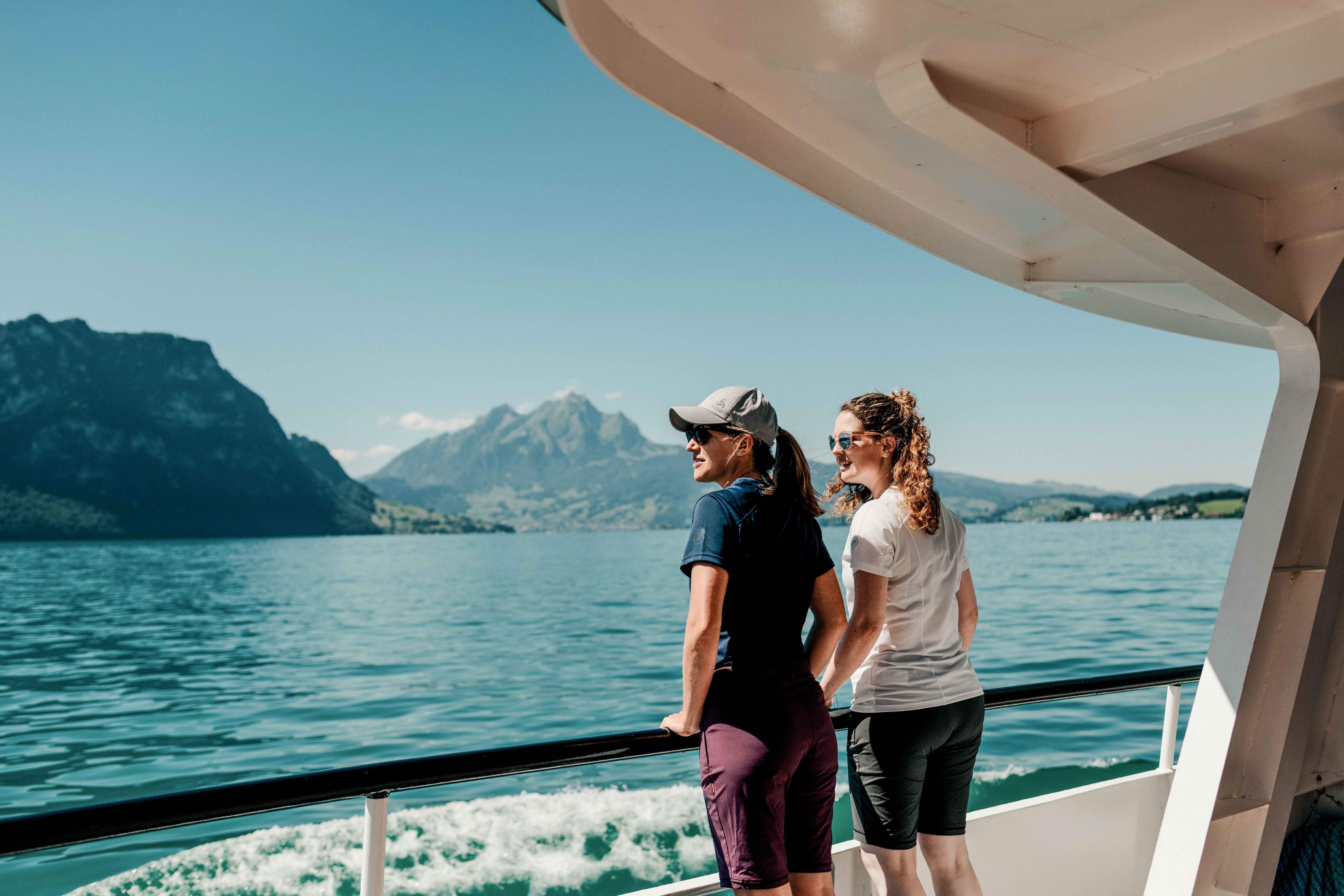 Deux femmes se tiennent sur le pont d'un bateau et regardent l'eau.