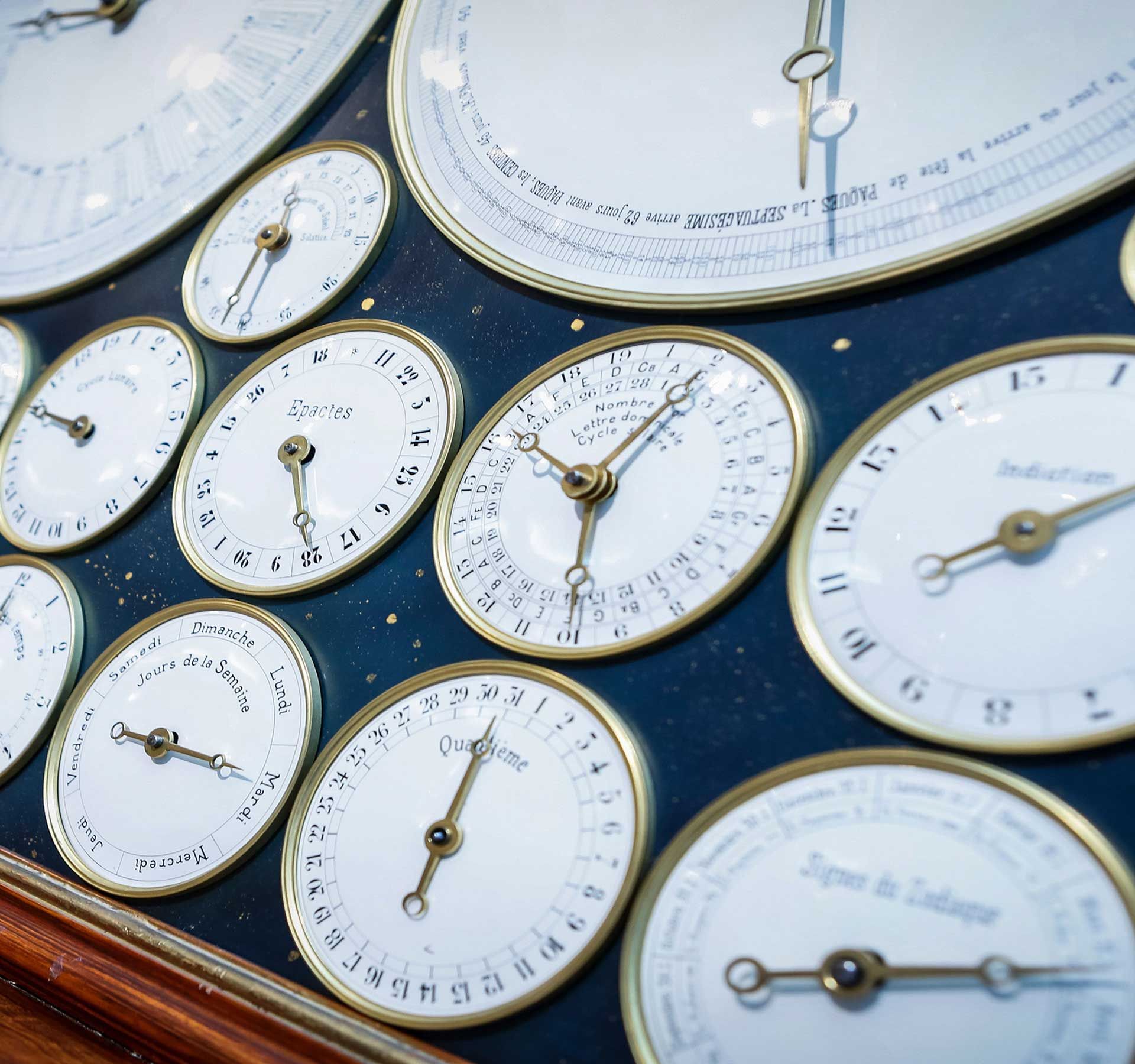 The picture shows old clock faces in a frame with a blue background.