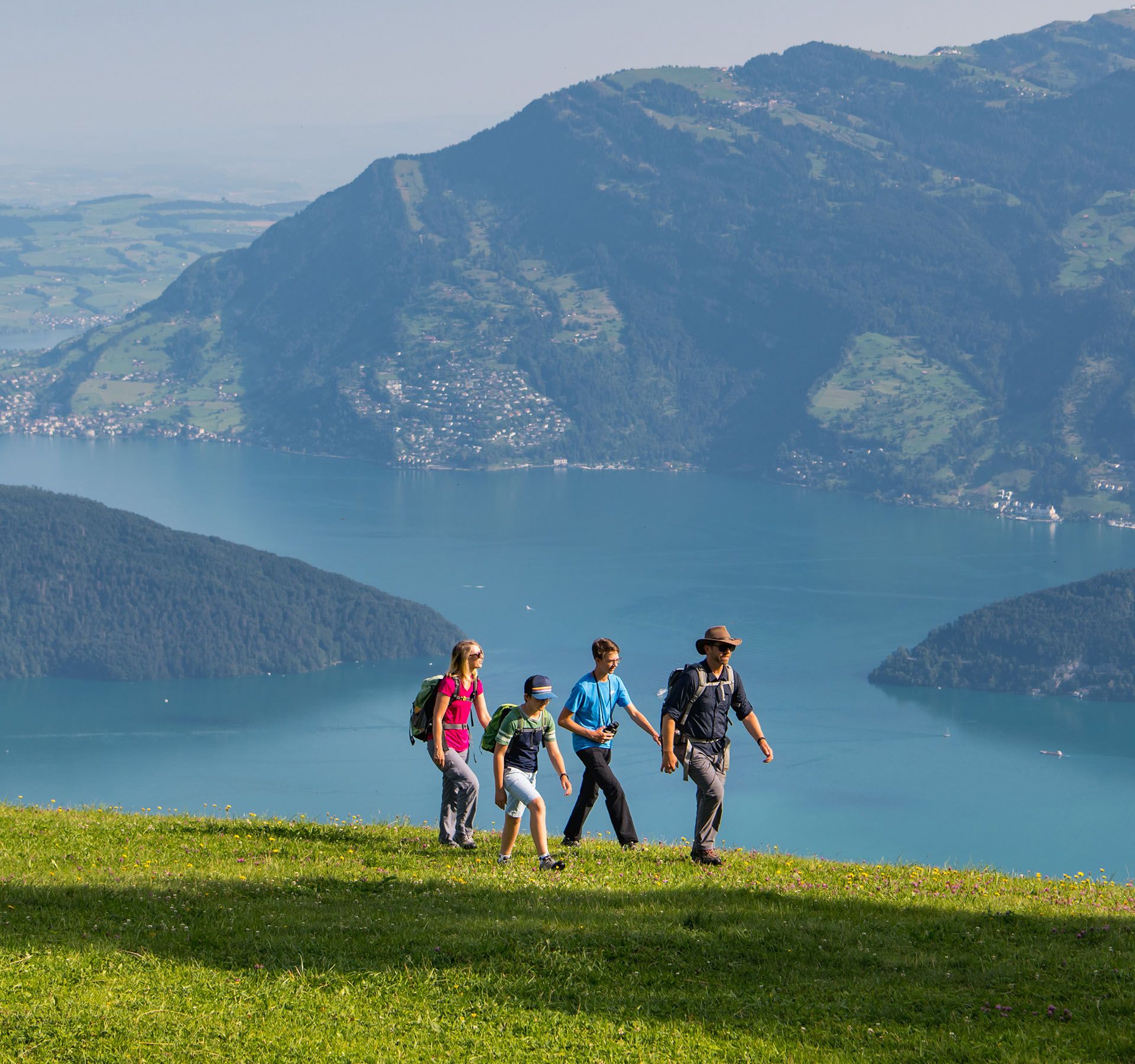 A hiking group on a green meadow on Klewenalp above Lake Lucerne.