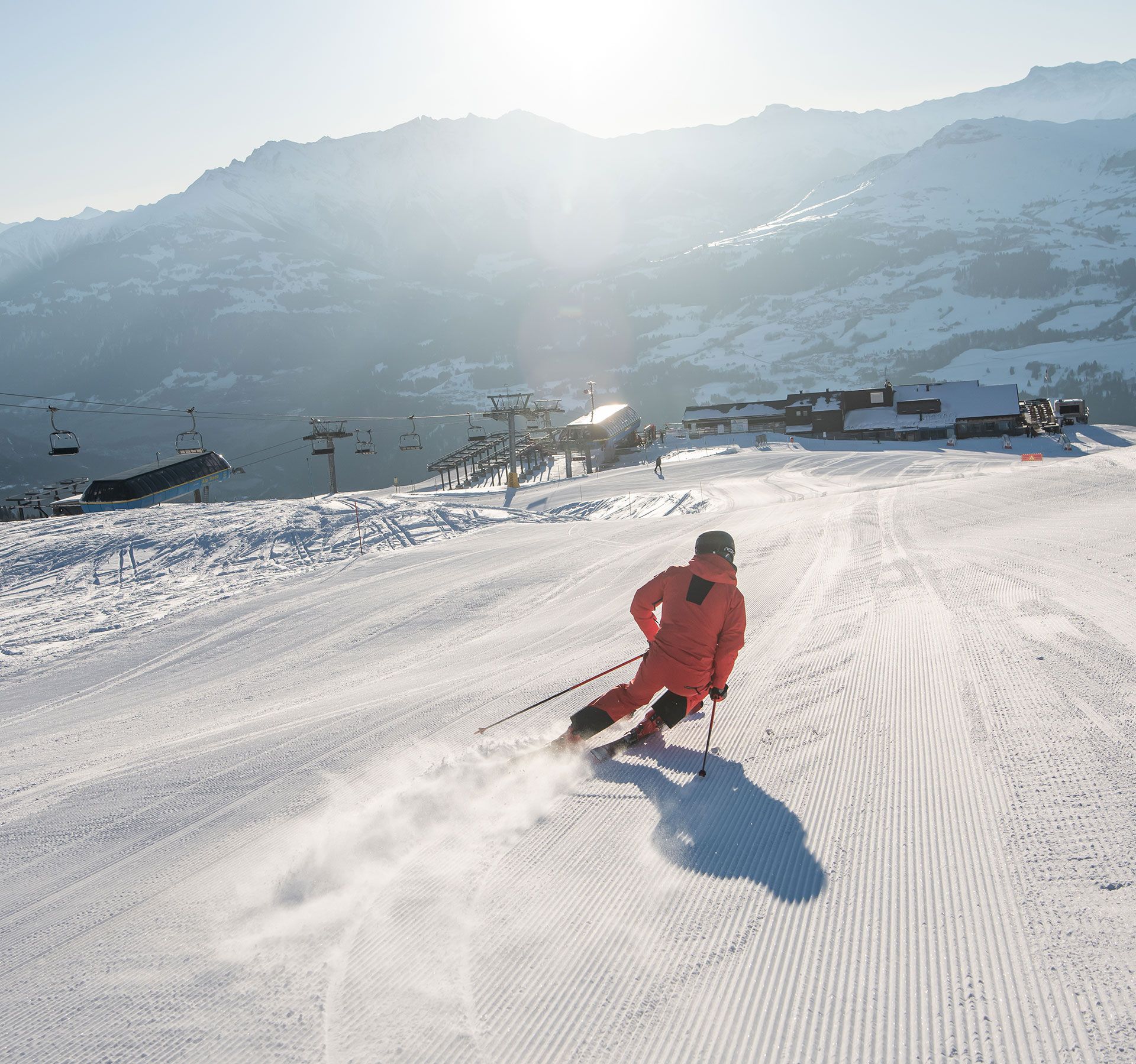Uno sciatore scende con grazia da una montagna innevata, dimostrando abilità e velocità in uno splendido scenario alpino.