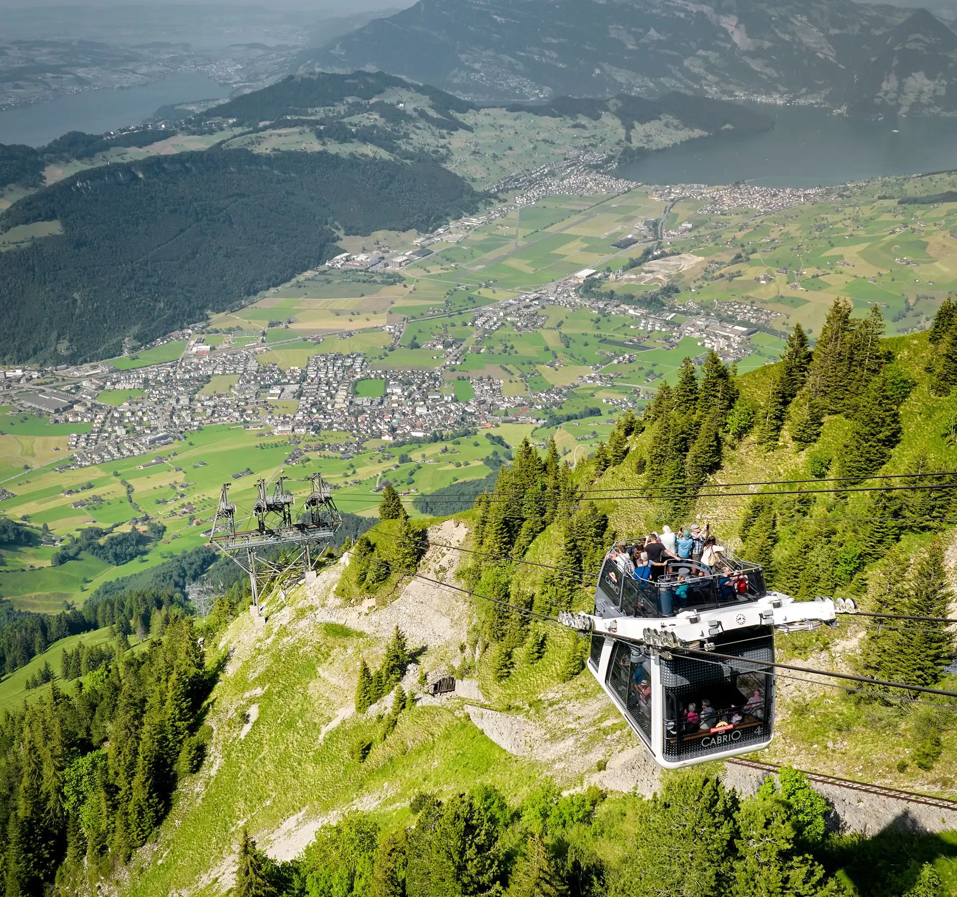 Passengers travel up the Stanserhorn on the CabriO cableway and enjoy the beautiful view.