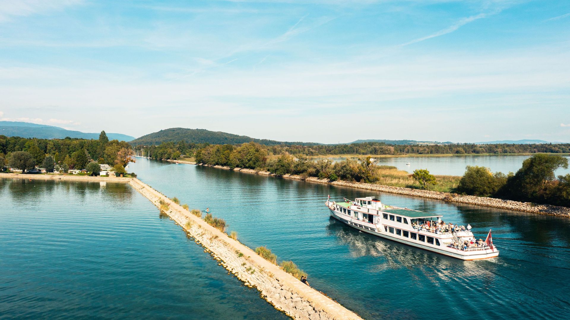 Ein Schiff fährt auf einem ruhigen Gewässer.