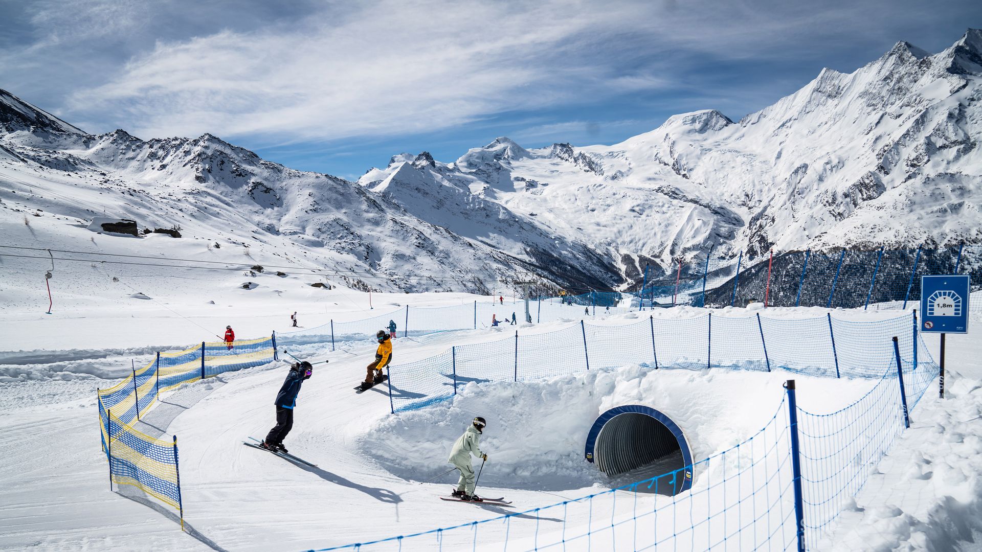 Gli sciatori attraversano un tunnel innevato.