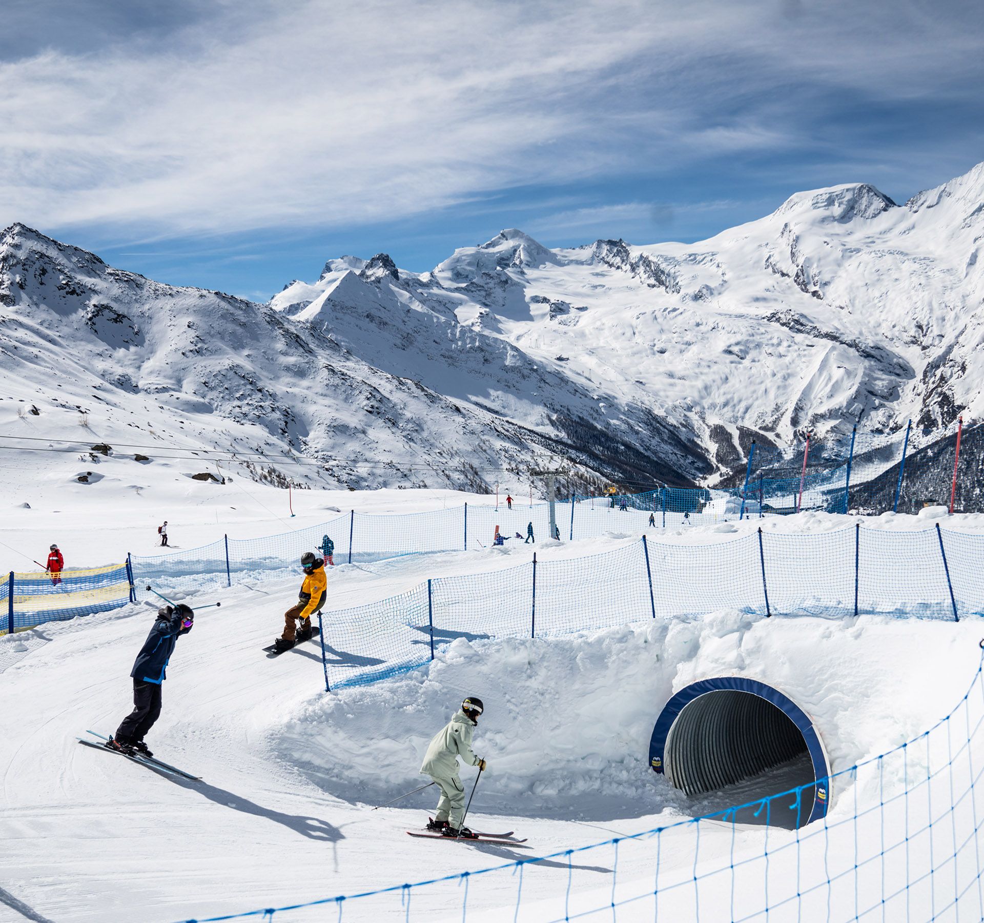 Skifahrer fahren durch einen schneebedeckten Tunnel.