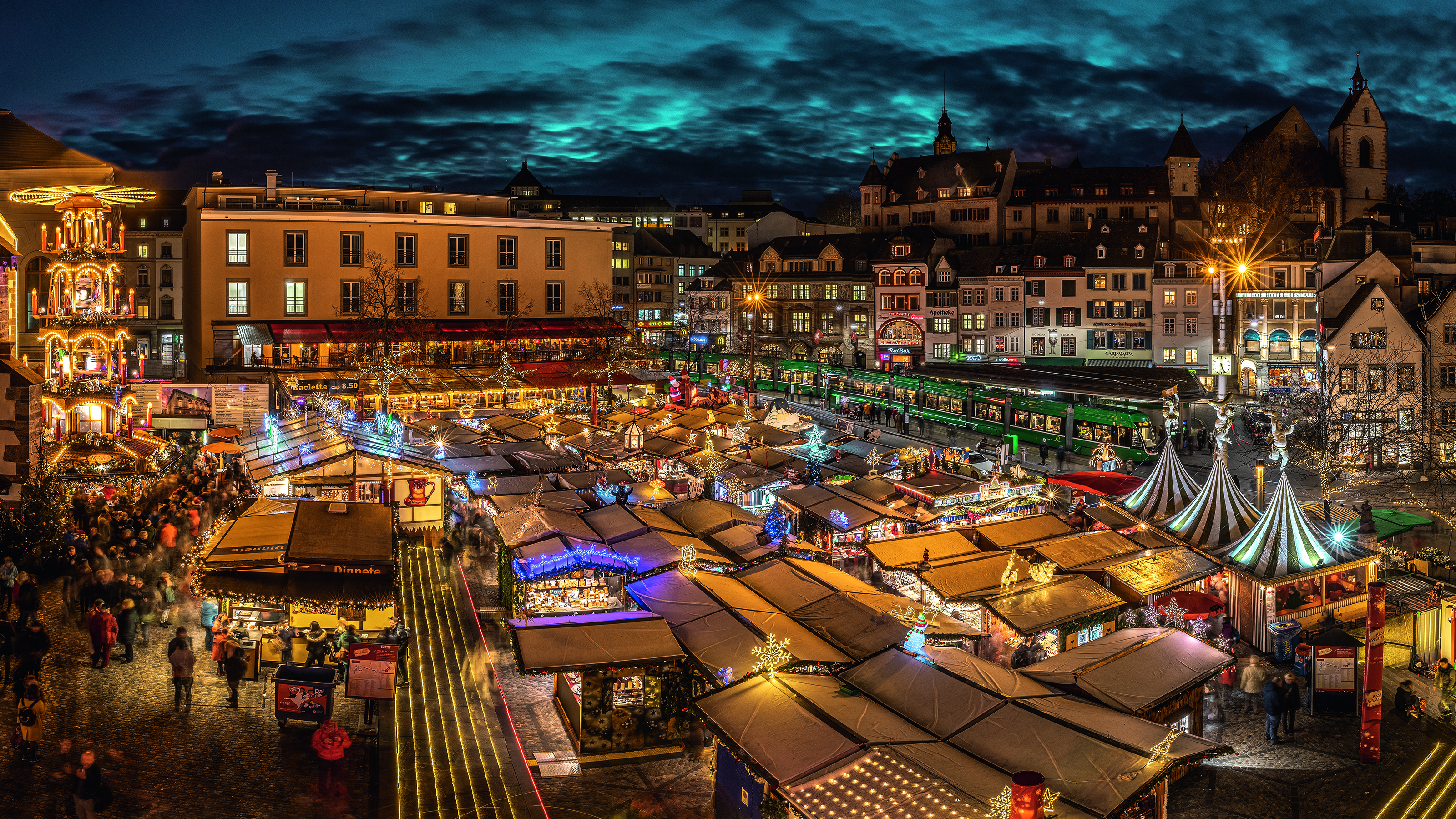 Un festoso mercatino di Natale notturno con bancarelle in legno colorate.