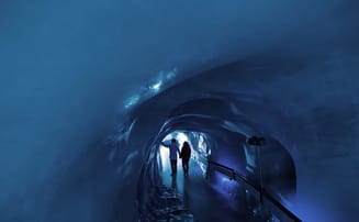 Visitors explore the fascinating glacier grotto on the Titlis, surrounded by impressive ice. 