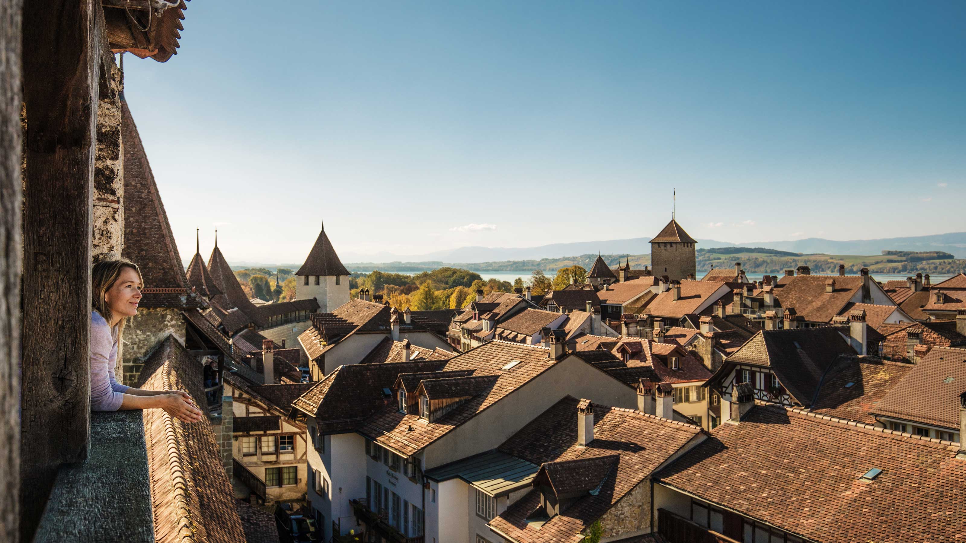 Eine Frau schaut über die Dächer von Murten und genießt die Aussicht.