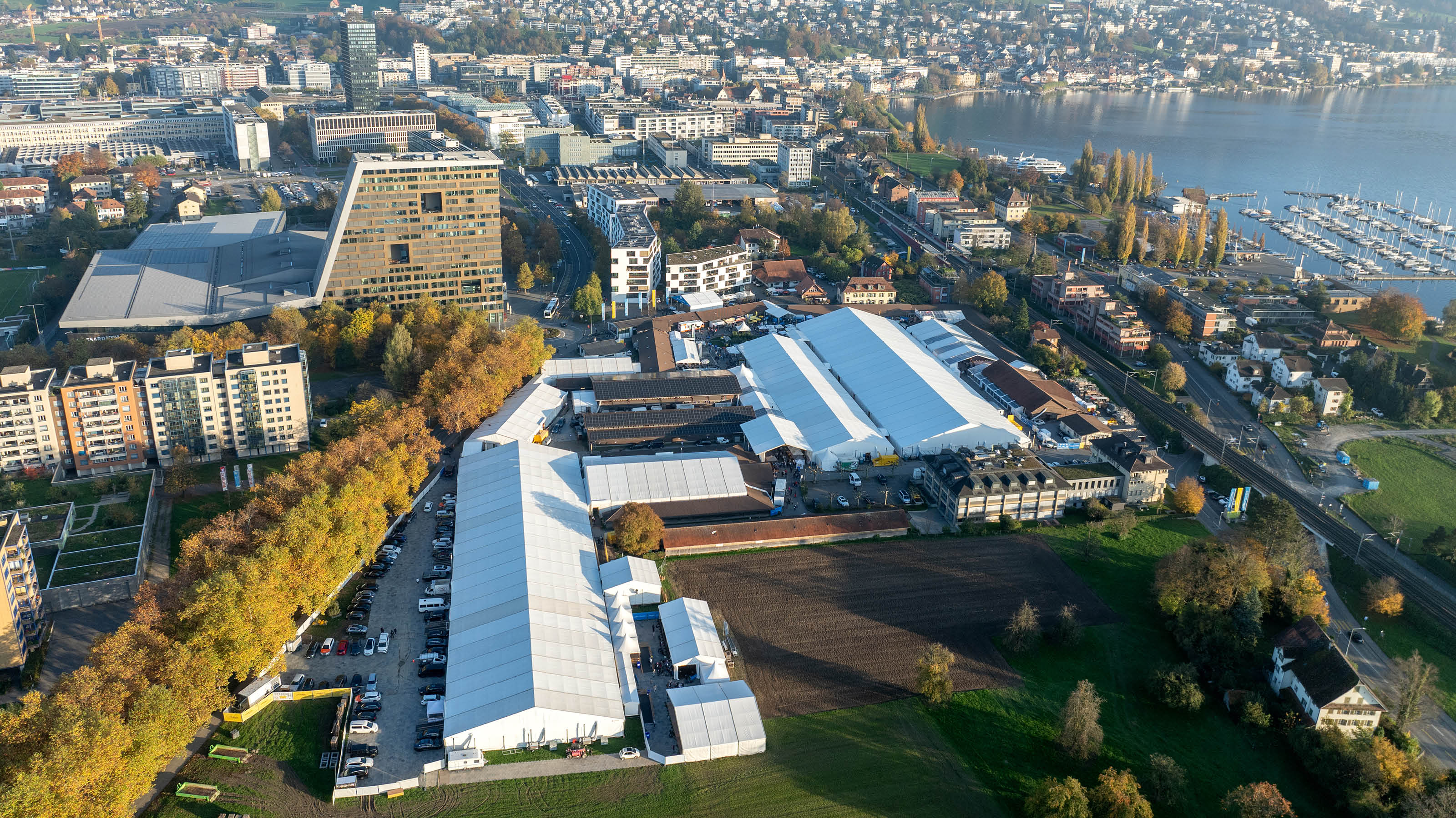 Zuger Messe 2026: mit Messezelten, umgeben von Stadtgebäuden und dem Zugersee im Hintergrund.