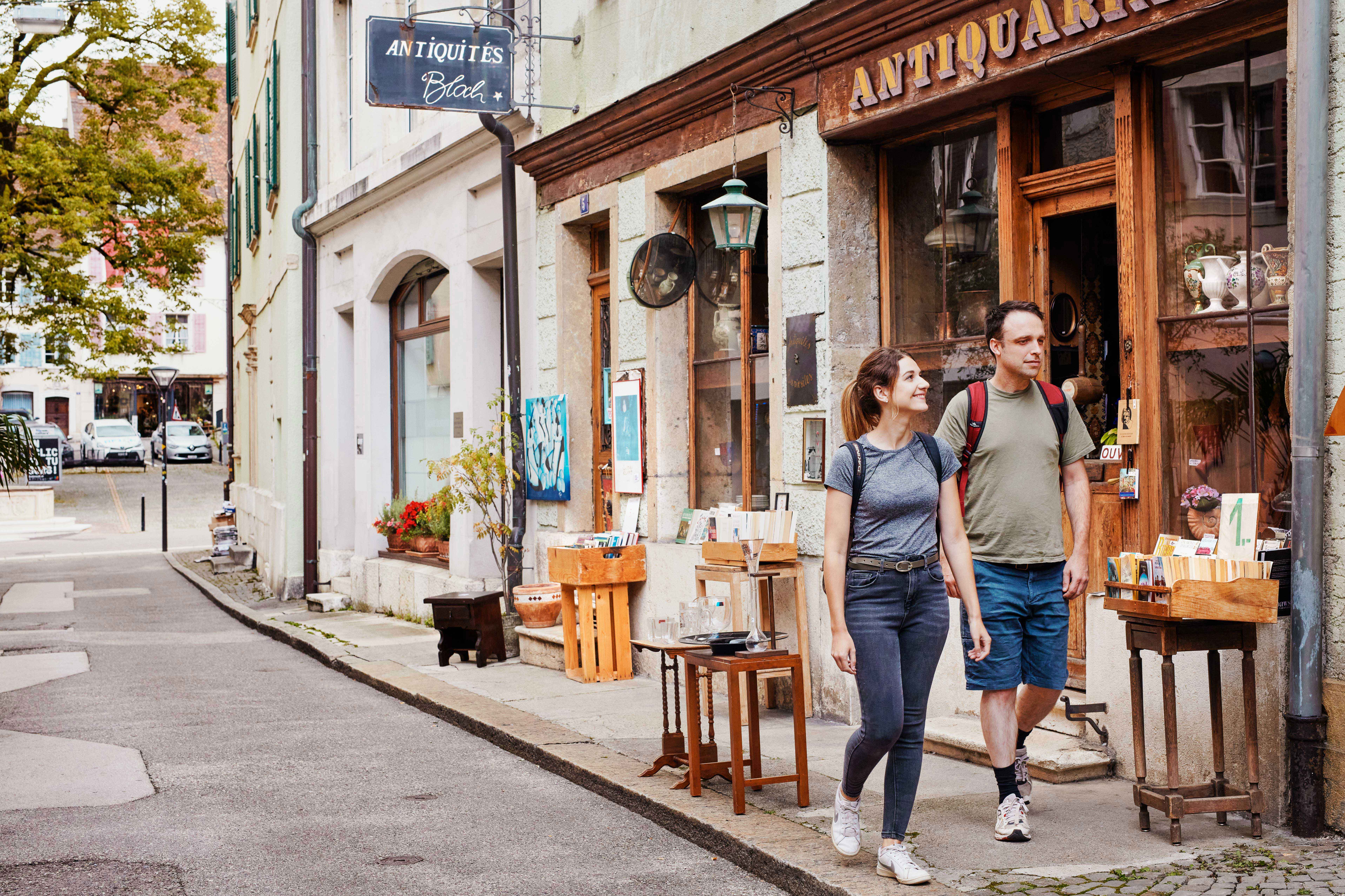 Un uomo e una donna passeggiano insieme lungo una strada cittadina, godendosi il tempo all'aperto.