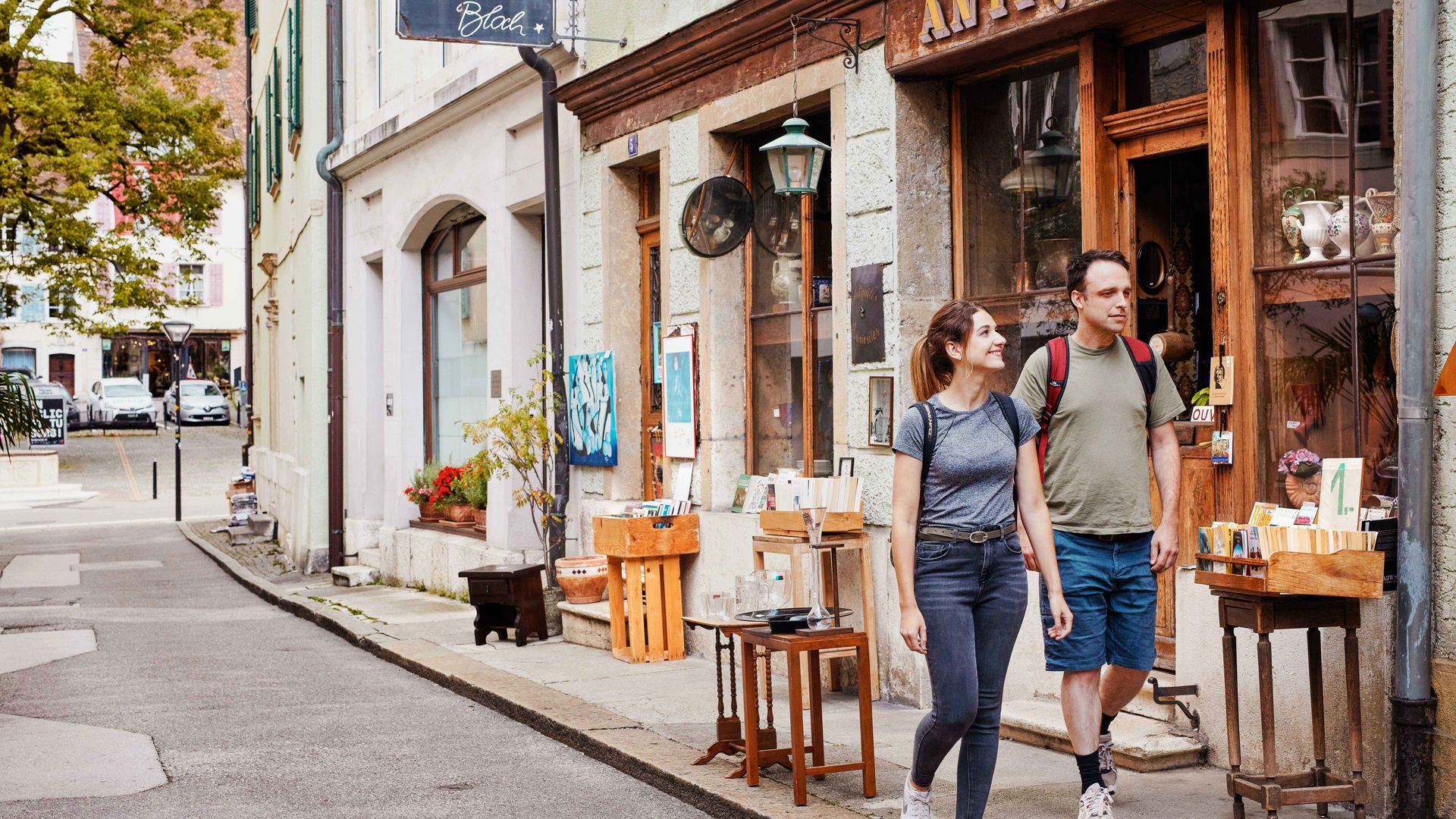Ein Mann und eine Frau schlendern gemeinsam eine Strasse in der Stadt entlang und geniessen ihre Zeit im Freien.