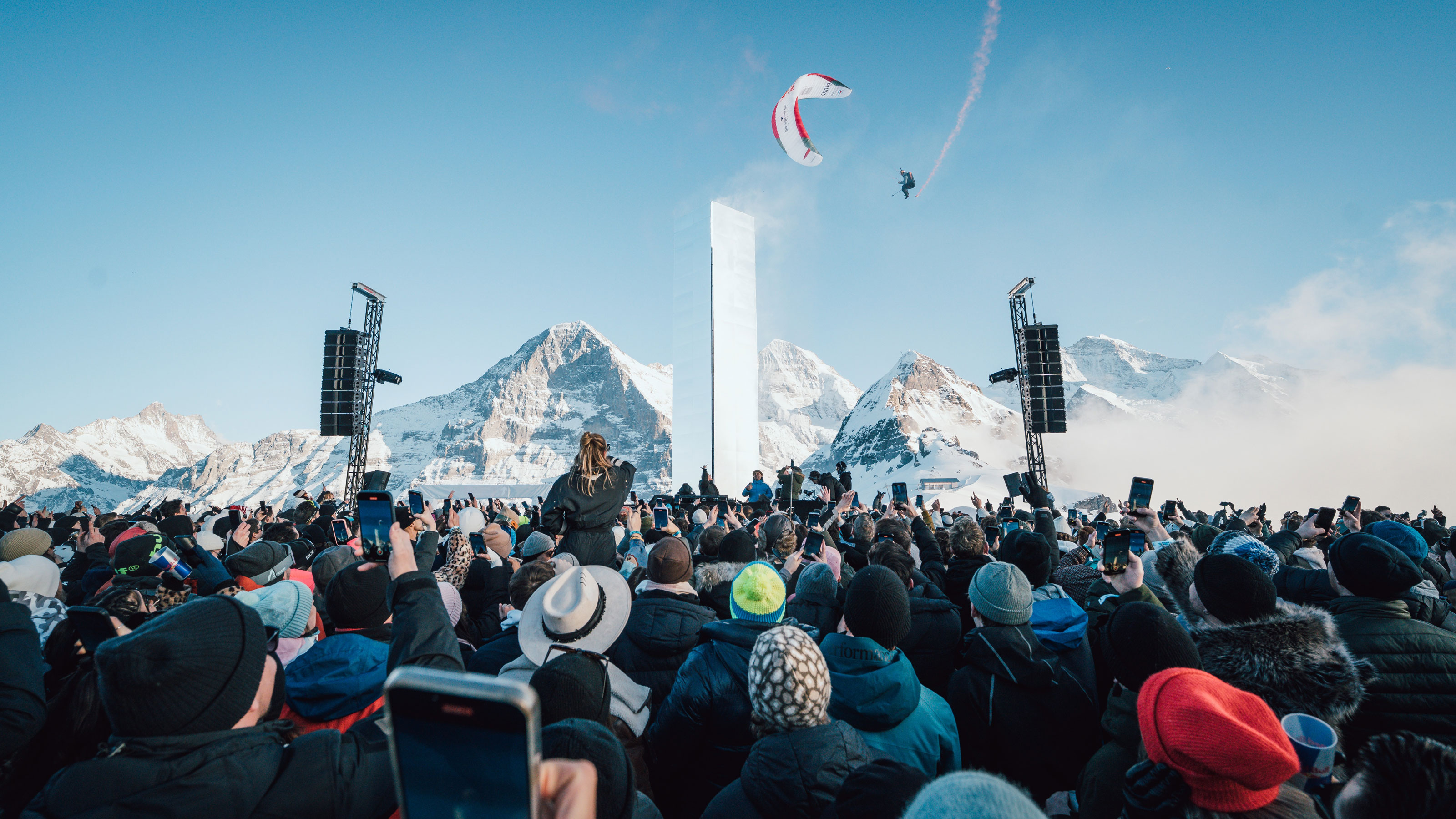 Persone che ballano al festival VSNZ in montagna, con un suggestivo panorama alpino sullo sfondo.