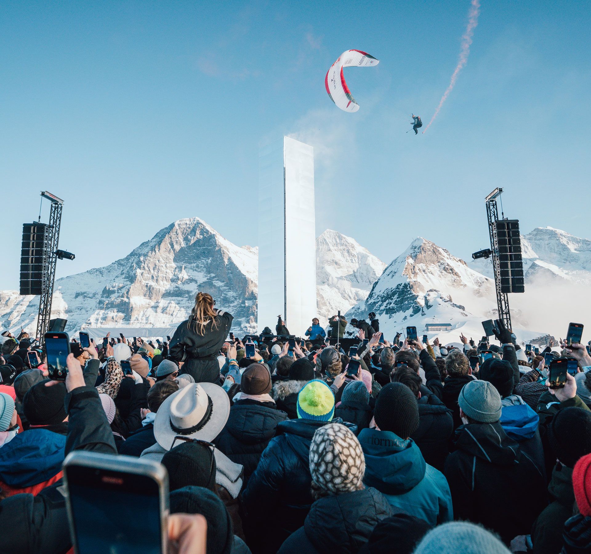 Persone che ballano al festival VSNZ in montagna, con un suggestivo panorama alpino sullo sfondo.