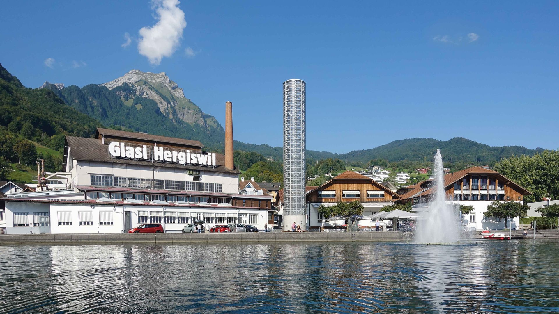 Un grand bâtiment se dresse majestueusement devant lequel coule gracieusement une fontaine, créant une atmosphère sereine.