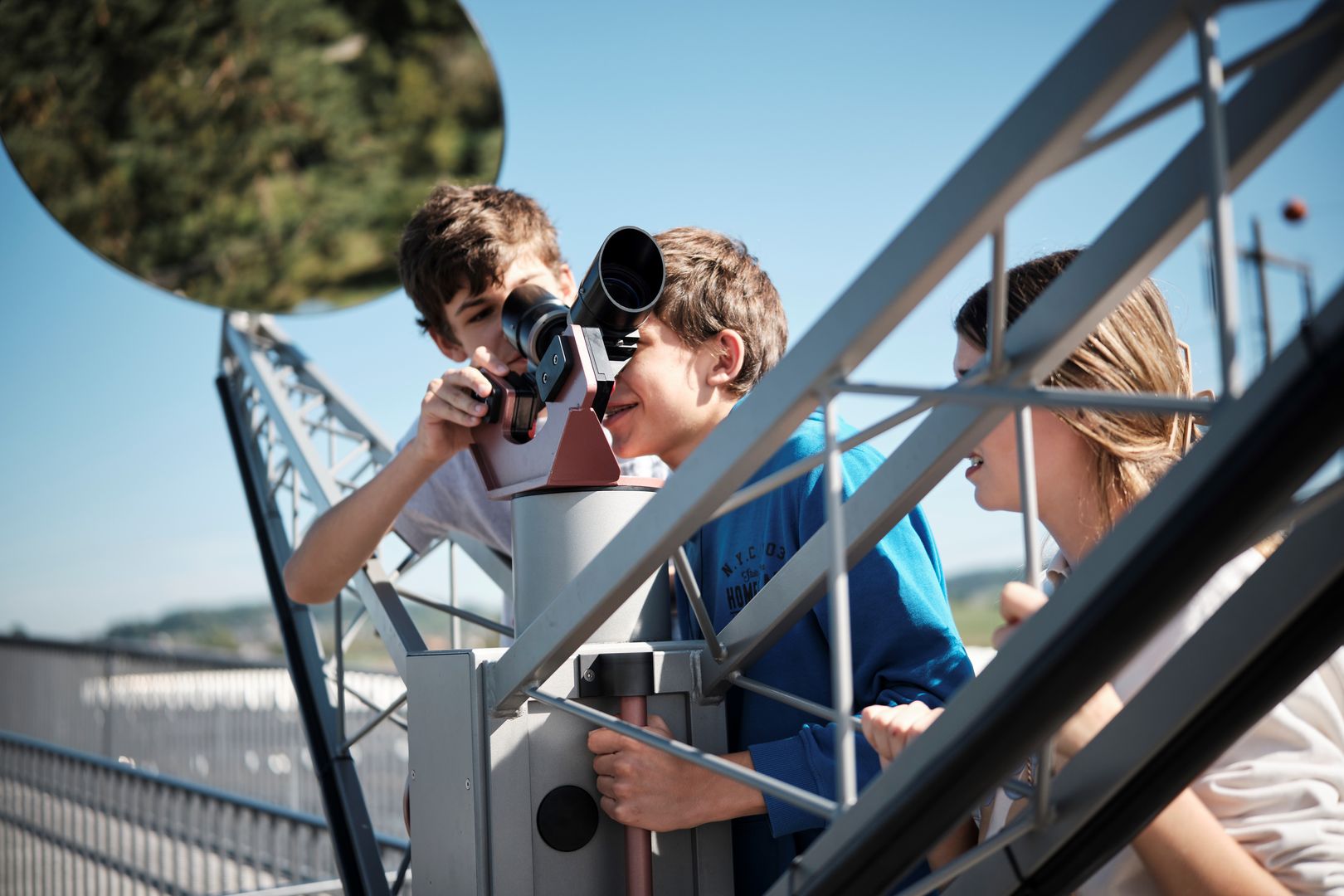 Gli studenti guardano attraverso un piccolo telescopio nell'area esterna del Technorama.
